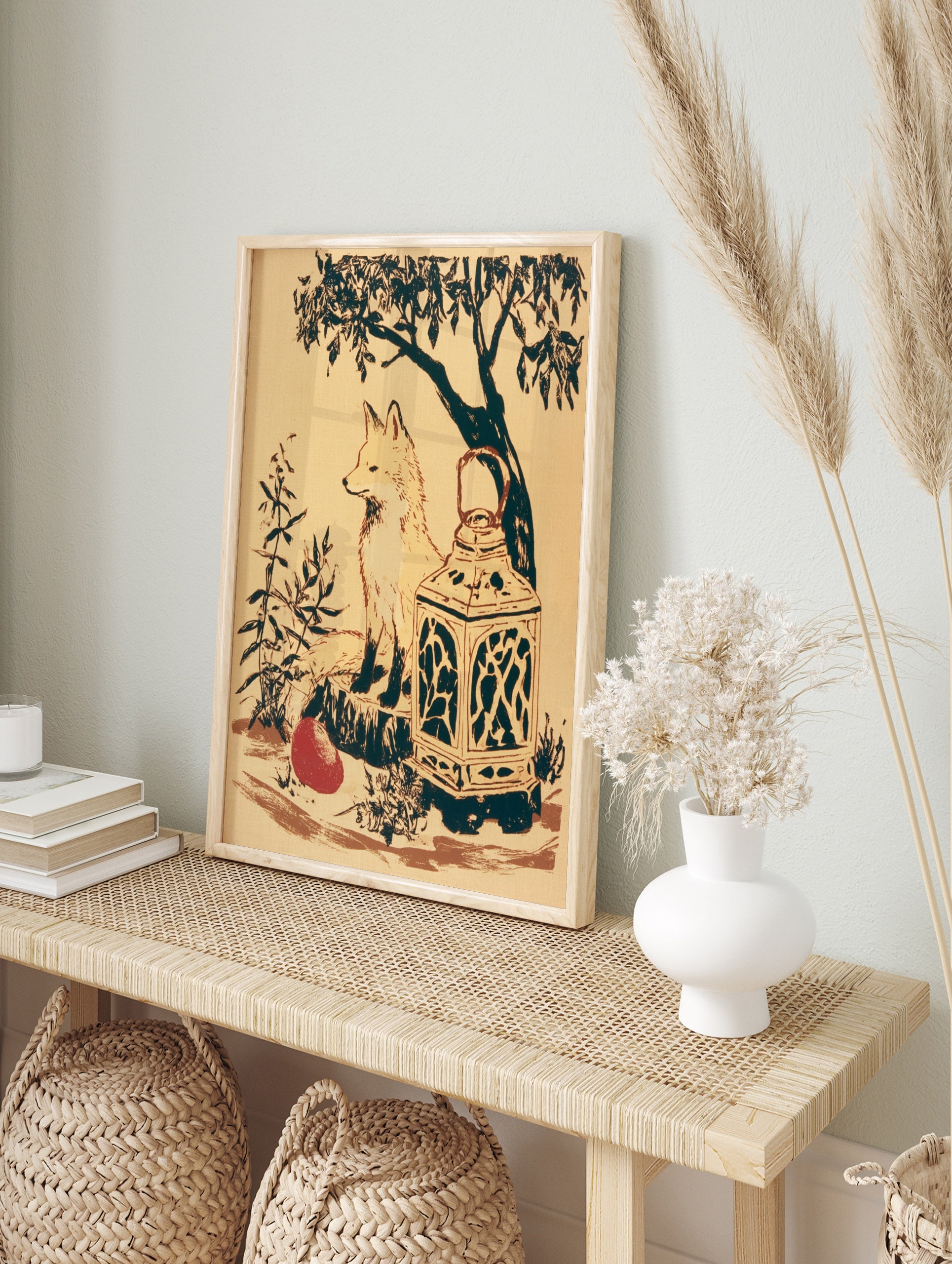 Illustrative fox sitting on a stump with a lantern and red fruit, woodland art print on cream, in an alternate framed mockup