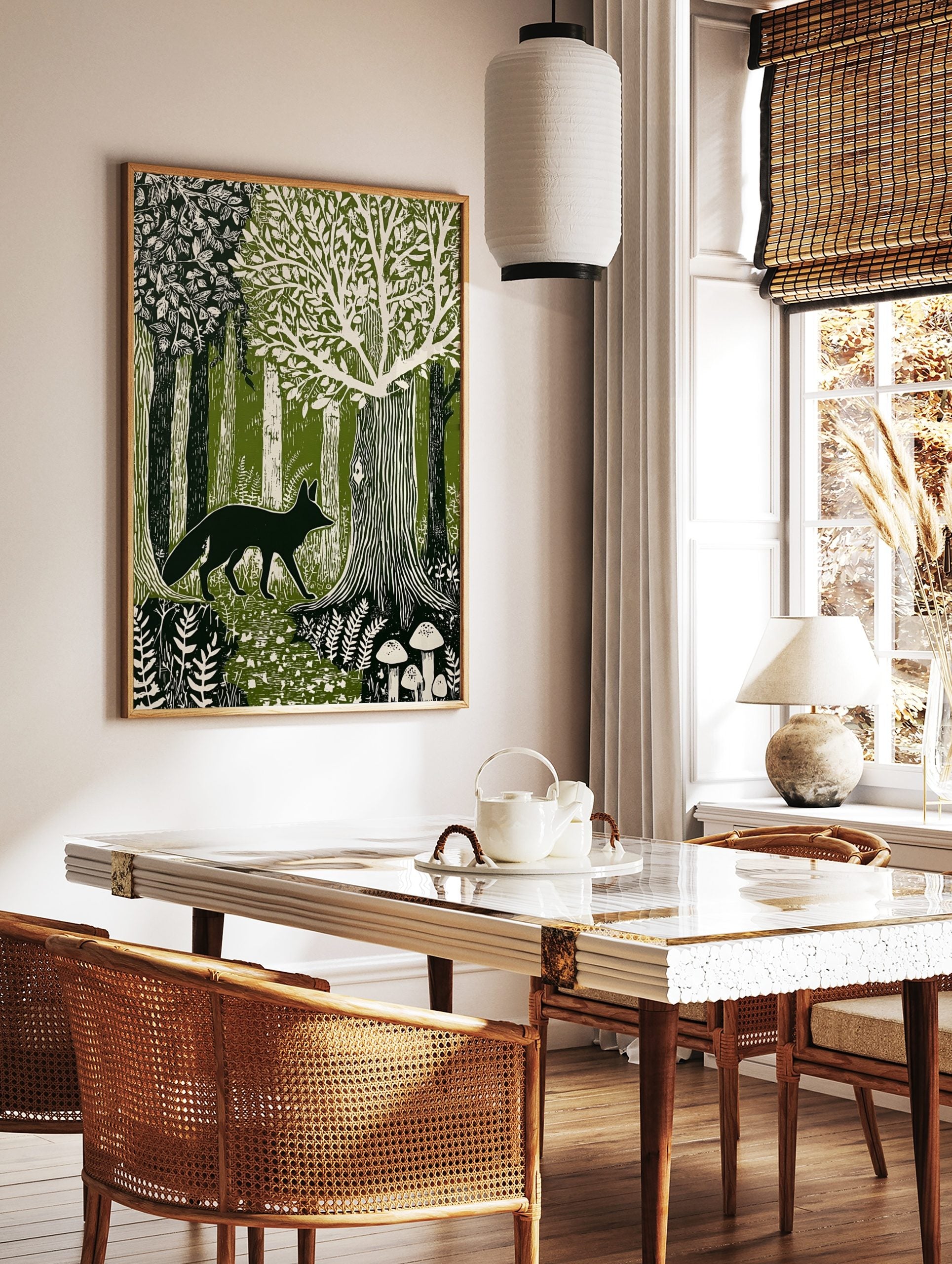 Linocut style forest art print with dark fox walking among green and white trees, ferns, and, in a styled room mockup
