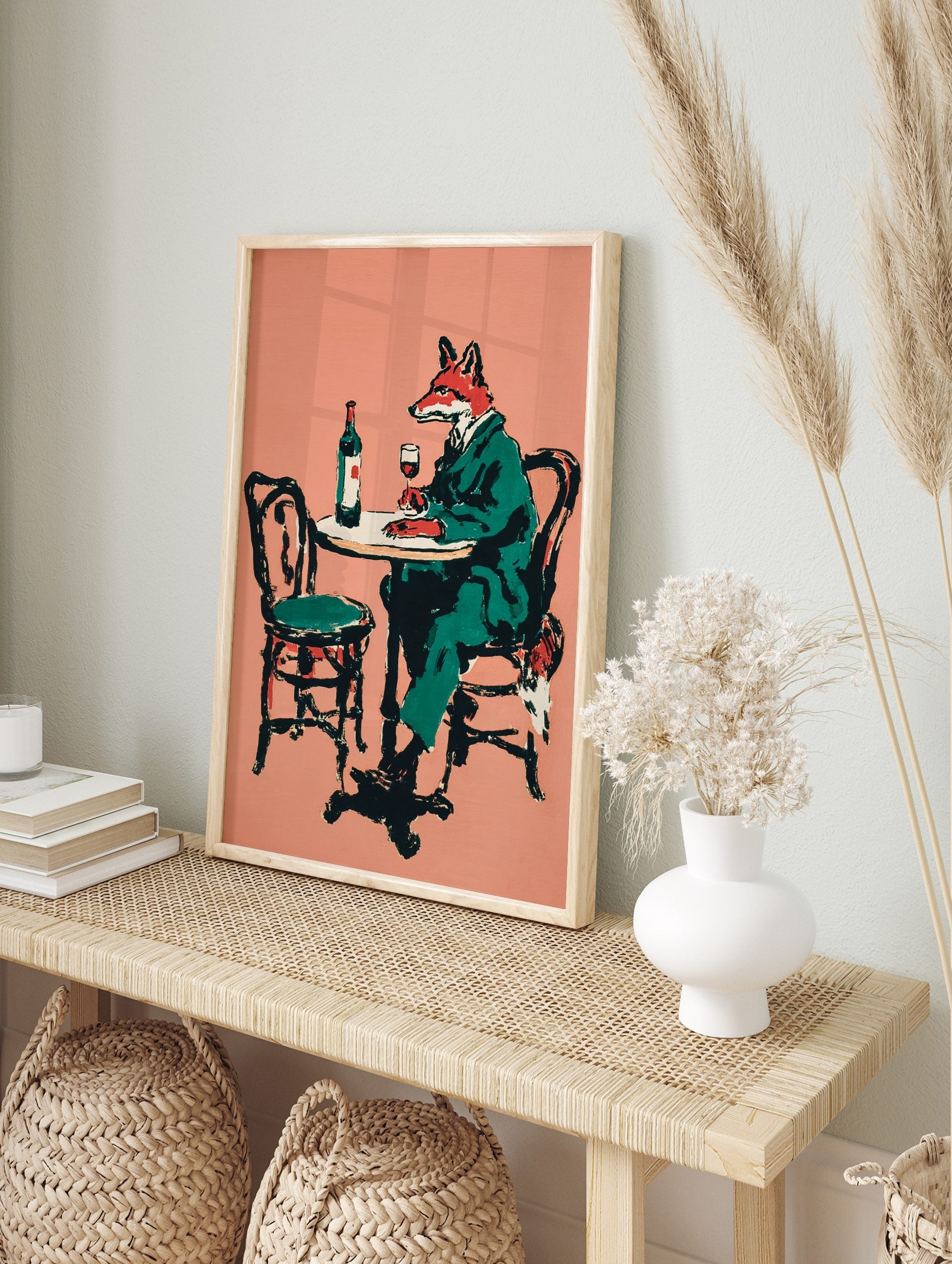 Illustrative print of a fox in a green suit sitting at a table with a bottle and glass of red, in an alternate framed mockup