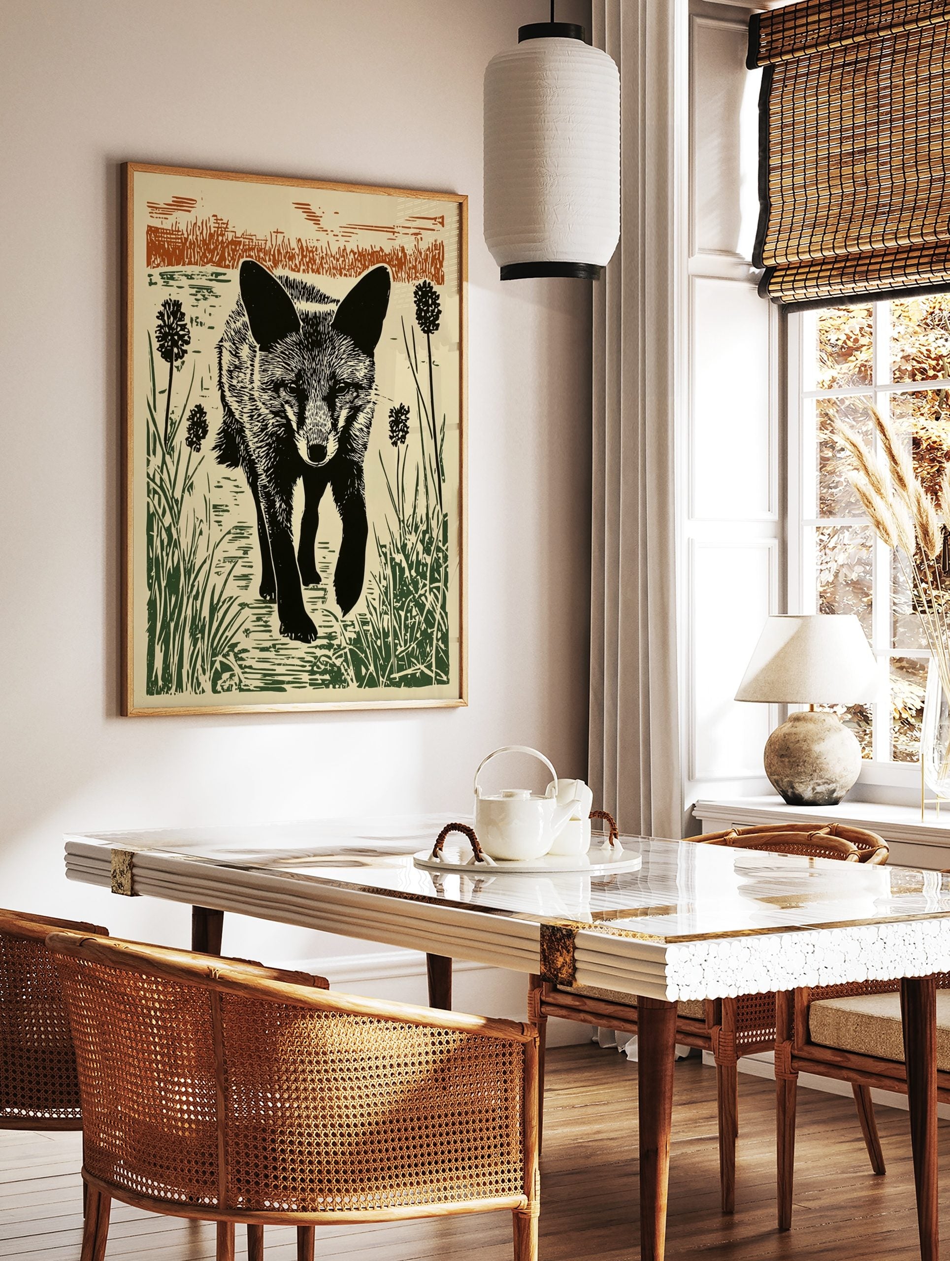Linocut style print of a black fox walking through green reeds and brown grasses against a light, in a styled room mockup