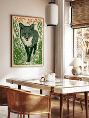 Linocut style art print of a fox walking through tall green grass with orange foliage above, in a styled room mockup