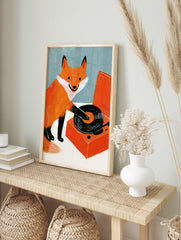 Illustration of an orange fox playing a black vinyl record on an orange turntable against a, in an alternate framed mockup