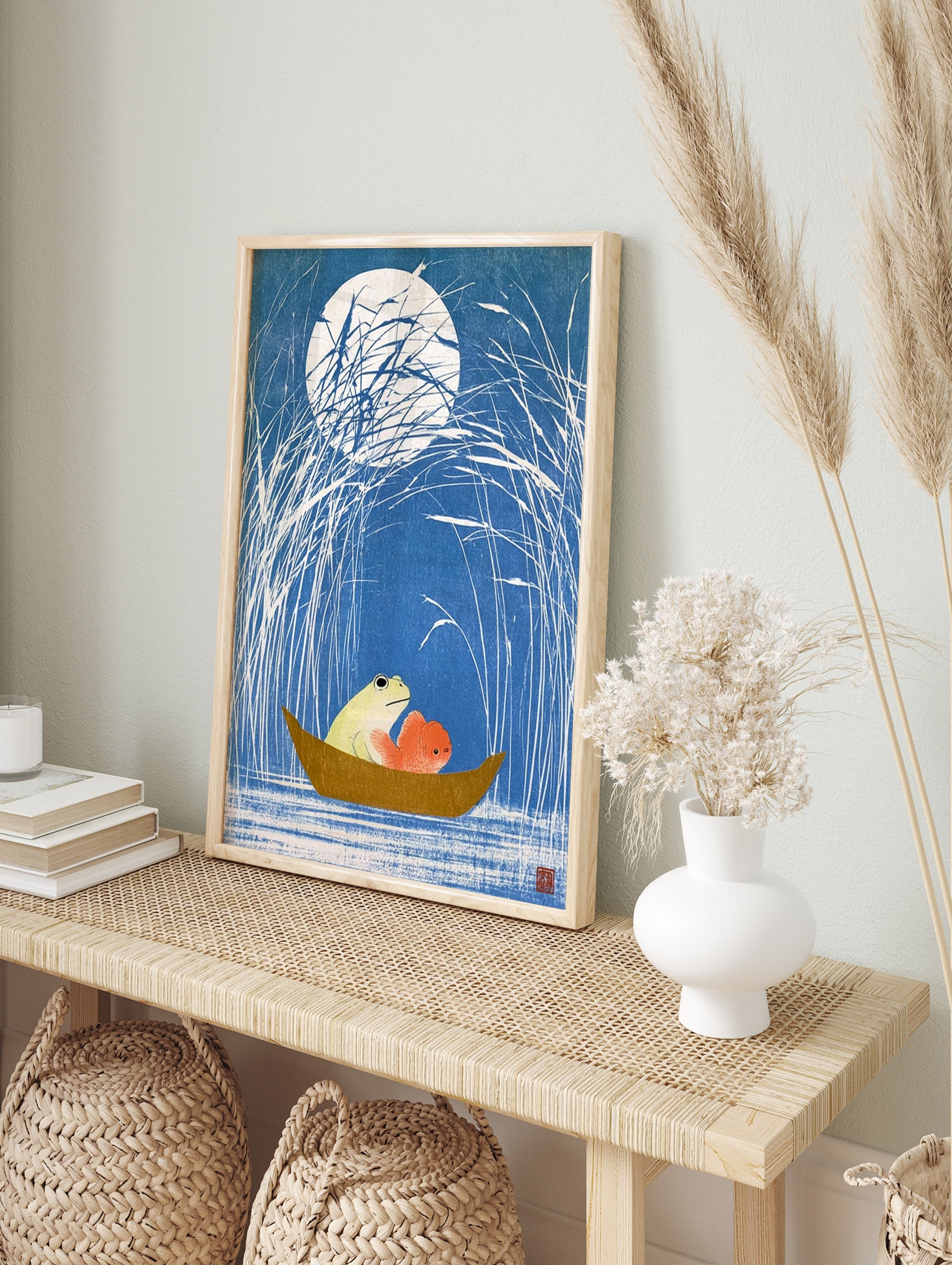 Japanese woodblock style art print of a frog and goldfish in a small boat under a full moon, in an alternate framed mockup