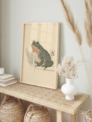 Humorous frog art print showing a frog sitting on a toilet reading a newspaper, in black, orange, and beige tones. - Image 3