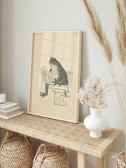 Humorous frog art print of a toad sitting on a toilet reading a newspaper, black line art on a cream background. - Image 3