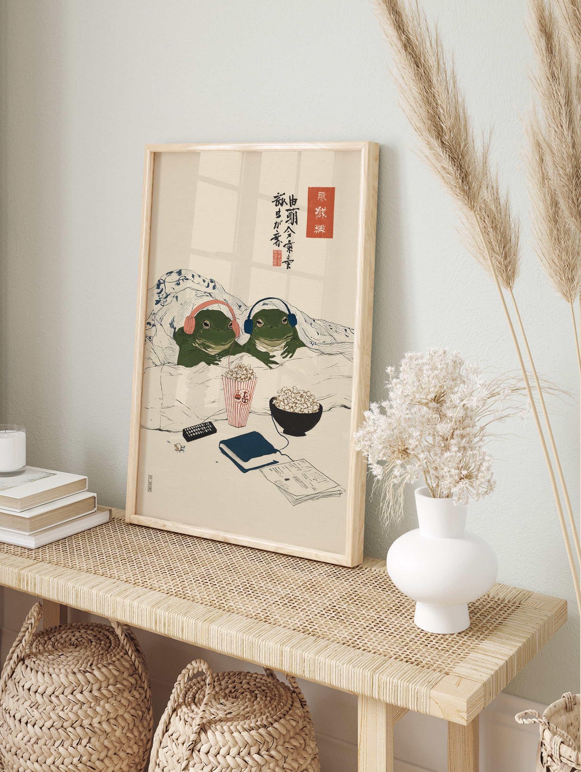 Japanese style frog art print showing two green frogs under a blanket with headphones, popcorn, and a remote for a cozy movie night. - Image 3
