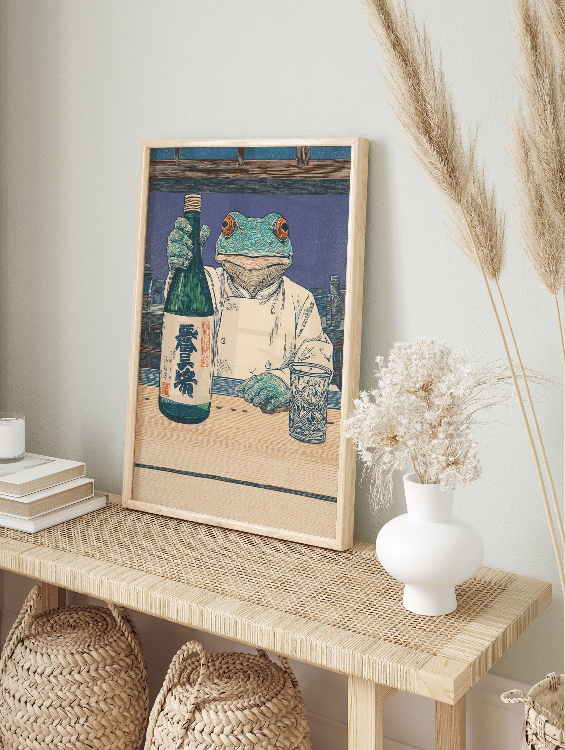 Frog chef in white coat holding sake bottle with kanji text, woodblock style print at a bar, in an alternate framed mockup