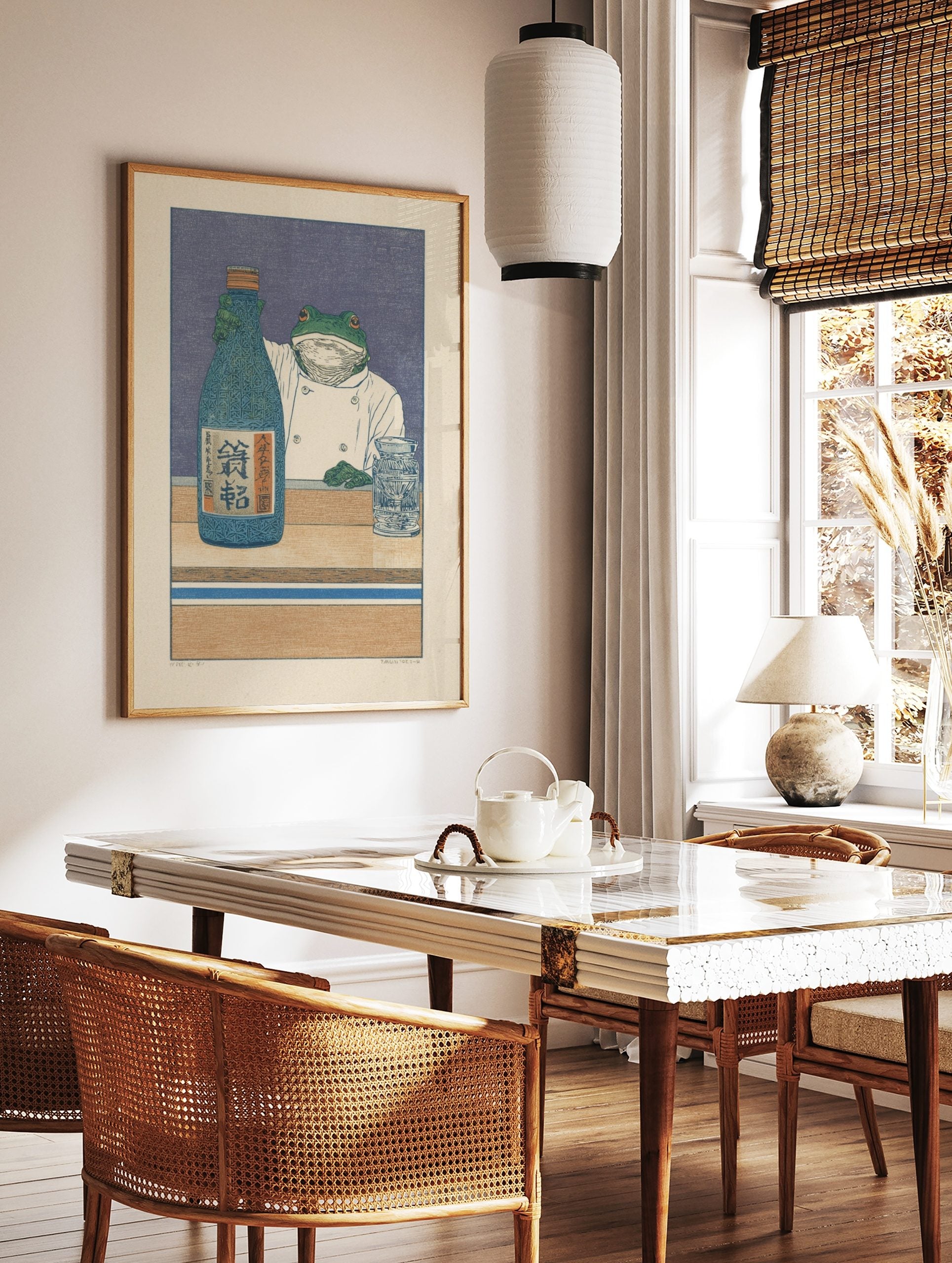 Illustrative print of a frog chef holding a blue sake bottle with Japanese Kanji on a wooden counter, in a styled room mockup