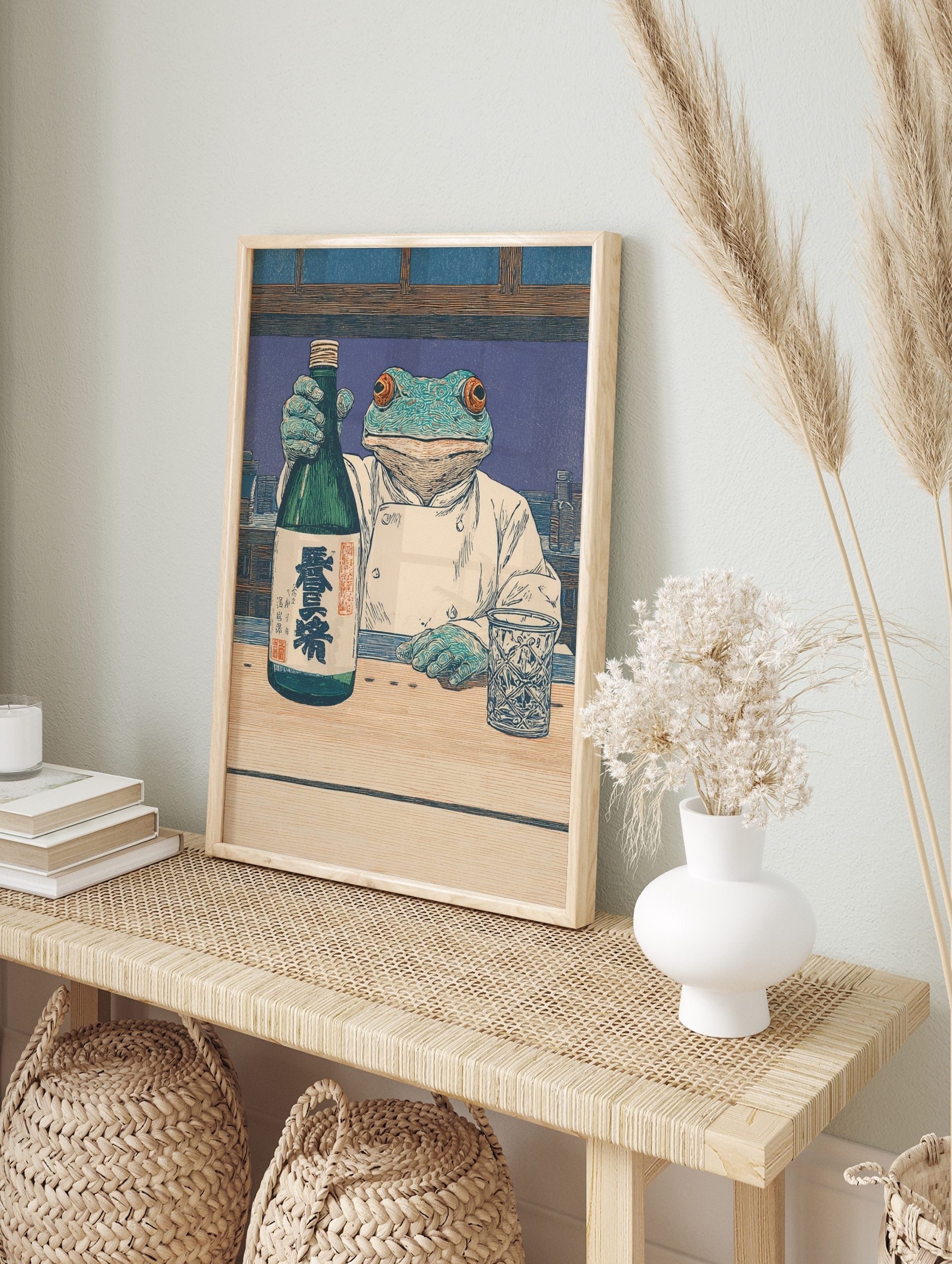 Ukiyo-e style print of a frog chef holding a green sake bottle with kanji, next to a, in an alternate framed mockup