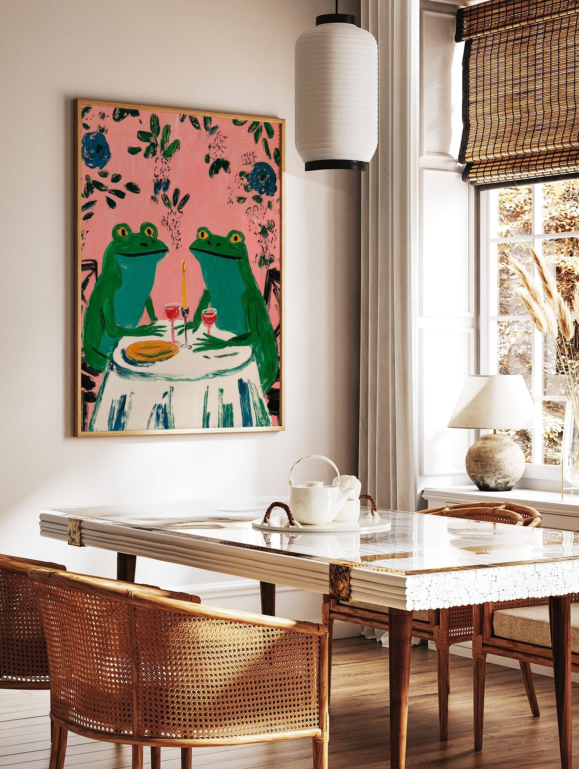 Two whimsical green frogs on a date at a table with wine and candle, pink background with leaves, in a styled room mockup