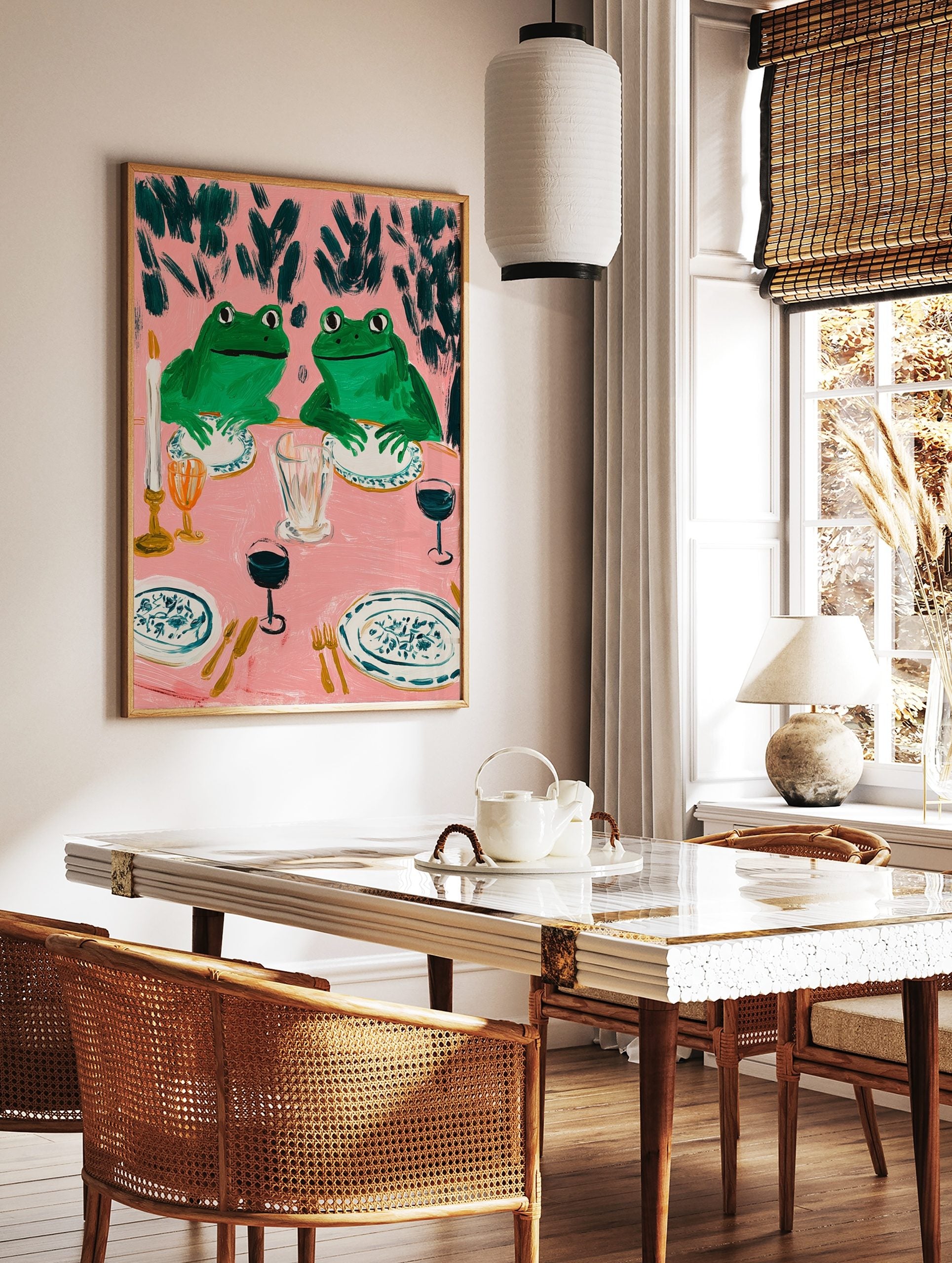 Humorous frog dinner party art print with two green frogs at a pink table set with plates, glasses, in a styled room mockup