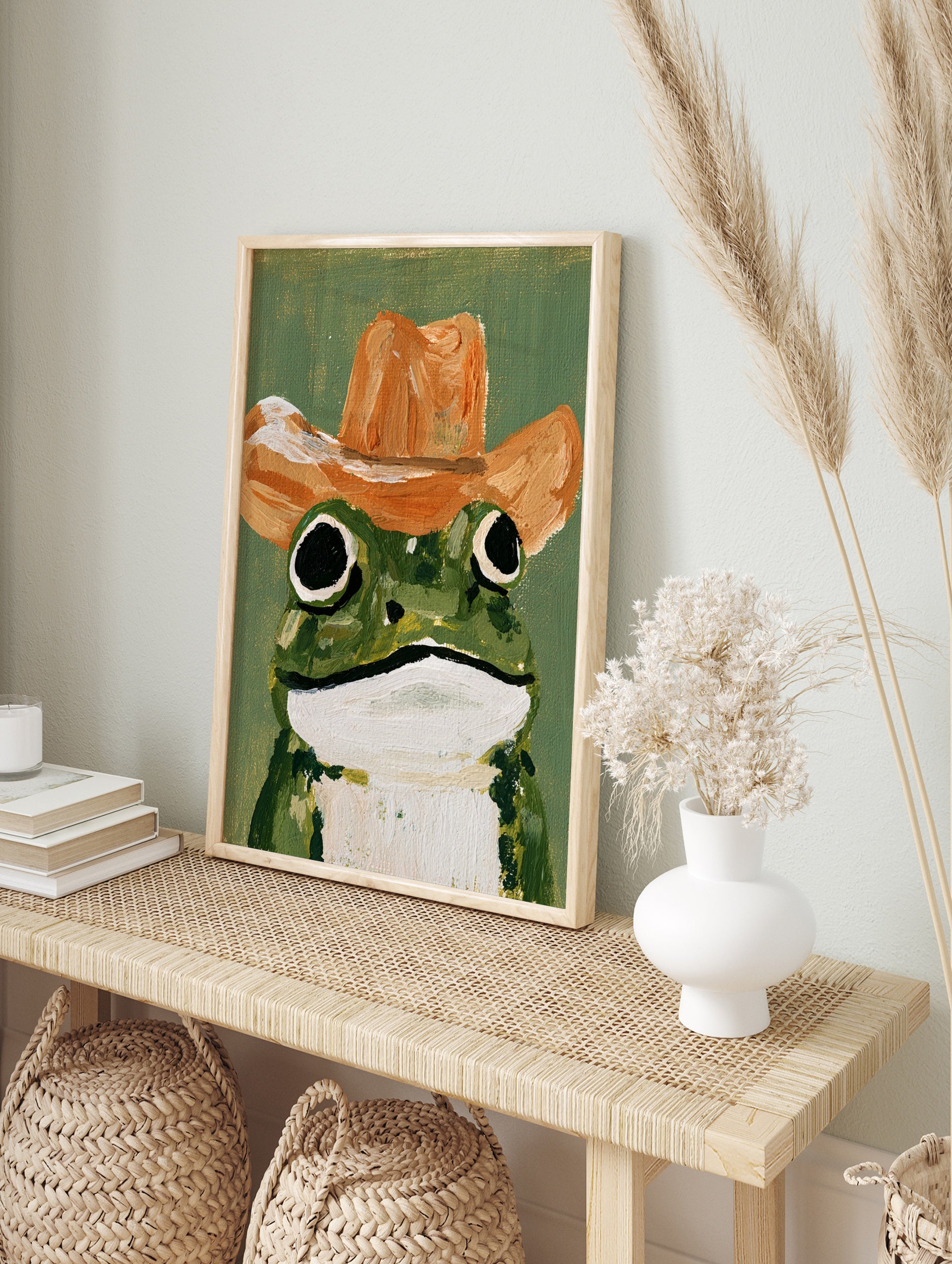 Painterly illustrative frog art print wearing a brown cowboy hat against a solid green, in an alternate framed mockup