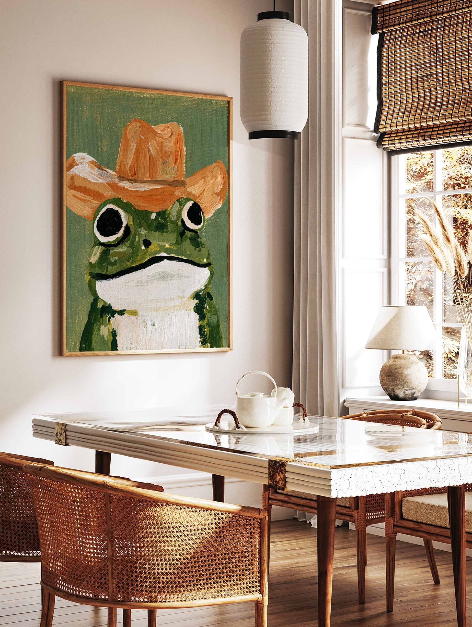 Painterly illustrative frog art print wearing a brown cowboy hat against a solid green background, in a styled room mockup