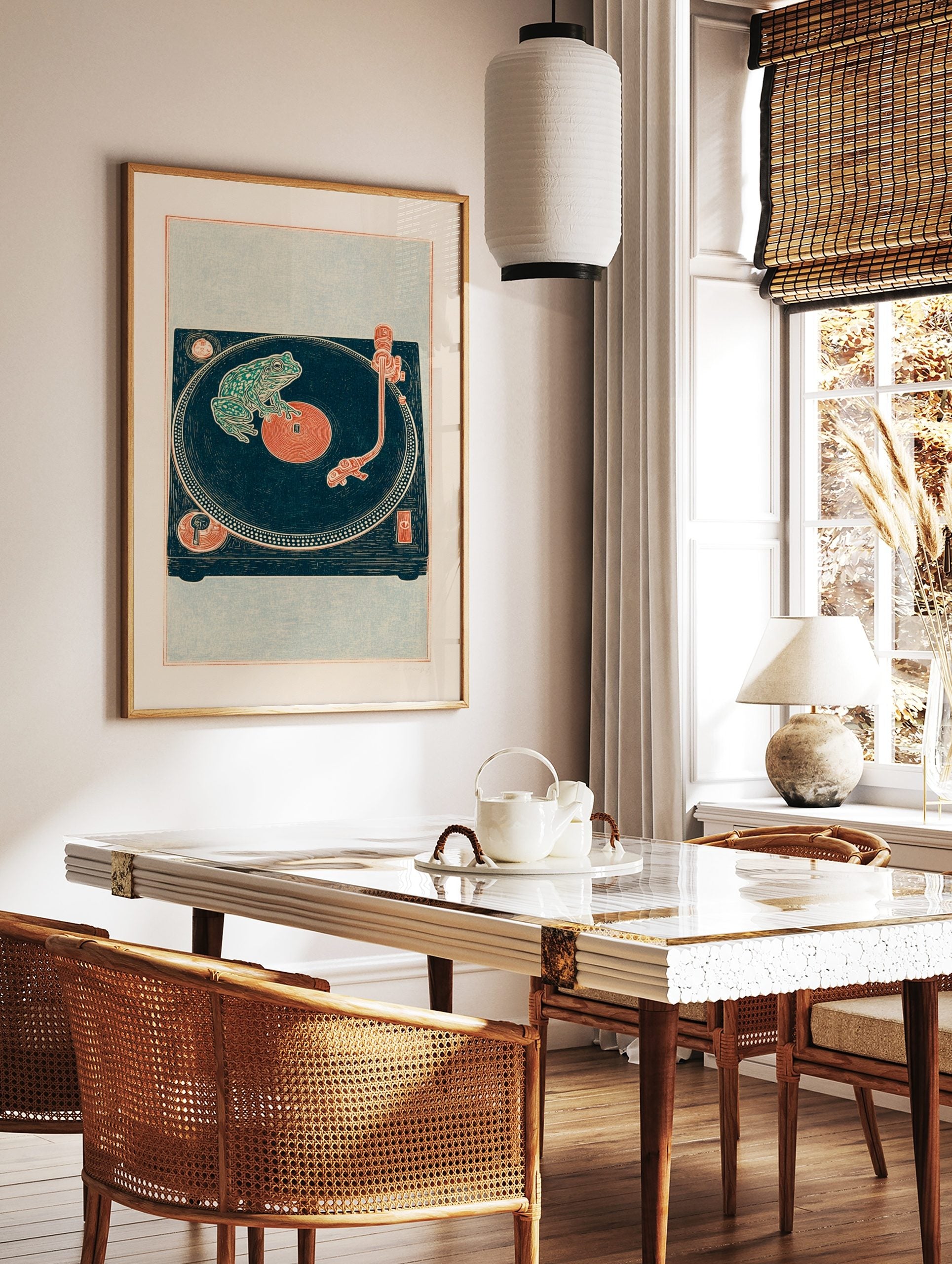 Illustrative green frog on a deep teal vinyl record and turntable art print with reddish-orange, in a styled room mockup