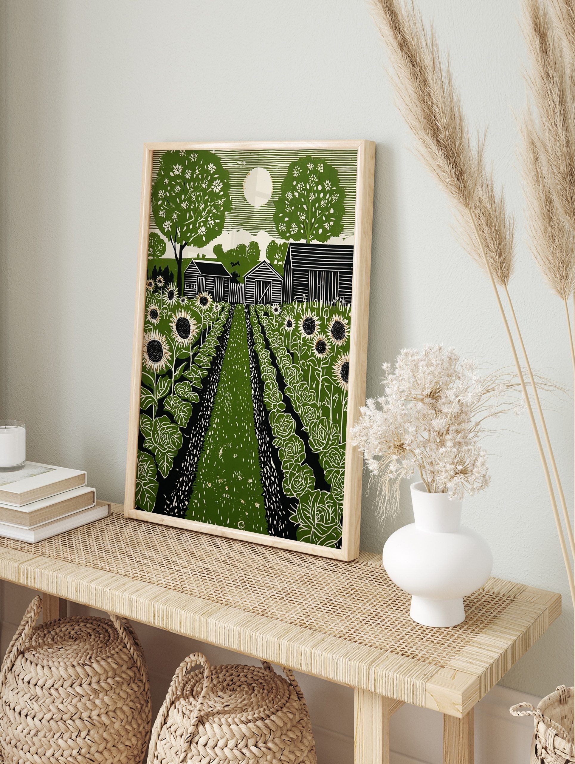 Green linocut print of a rural garden with sunflowers, cabbage, barns, trees, and a full moon, in an alternate framed mockup