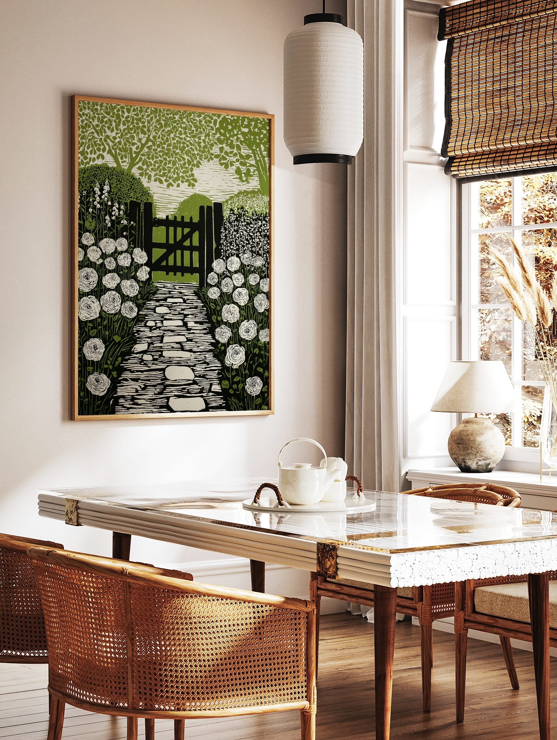 Linocut style print of a garden path leading to a wooden gate, flanked by white roses and green, in a styled room mockup