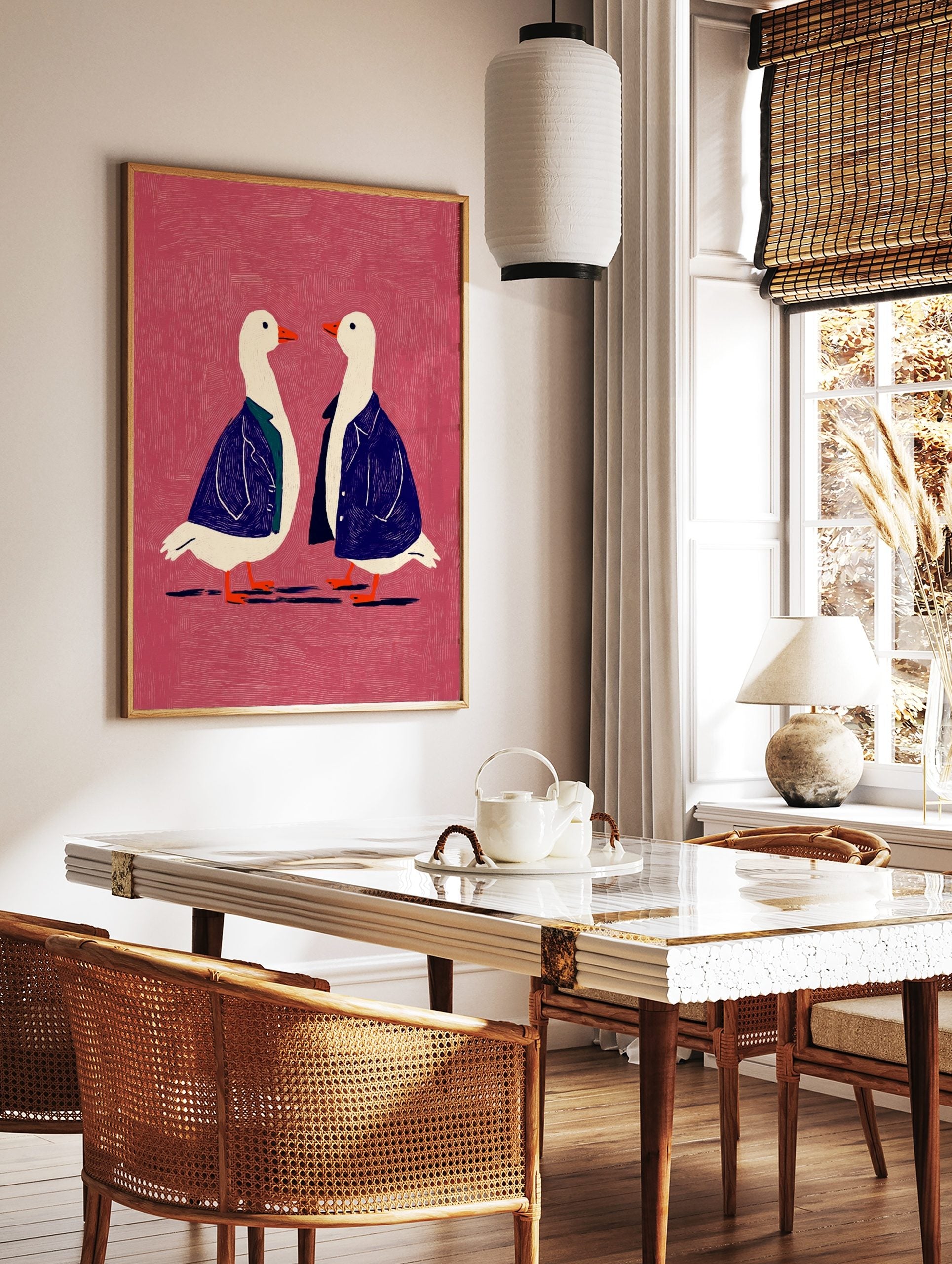 Two white geese in blue jackets with orange beaks on a textured pink background, facing each other, in a styled room mockup