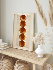 Minimalist geometric wall art with five stacked terracotta circles and vertical lines on a, in an alternate framed mockup