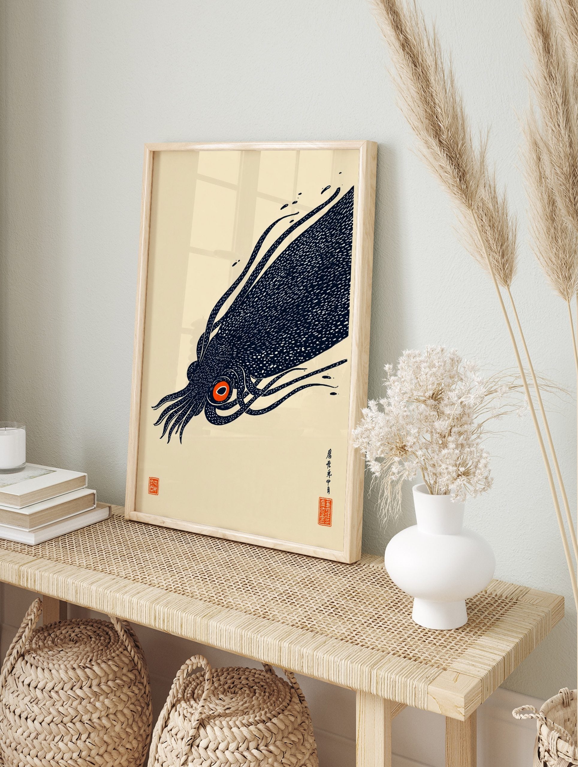 Illustrative print of a dark navy giant squid with a bright orange eye, featuring Japanese, in an alternate framed mockup