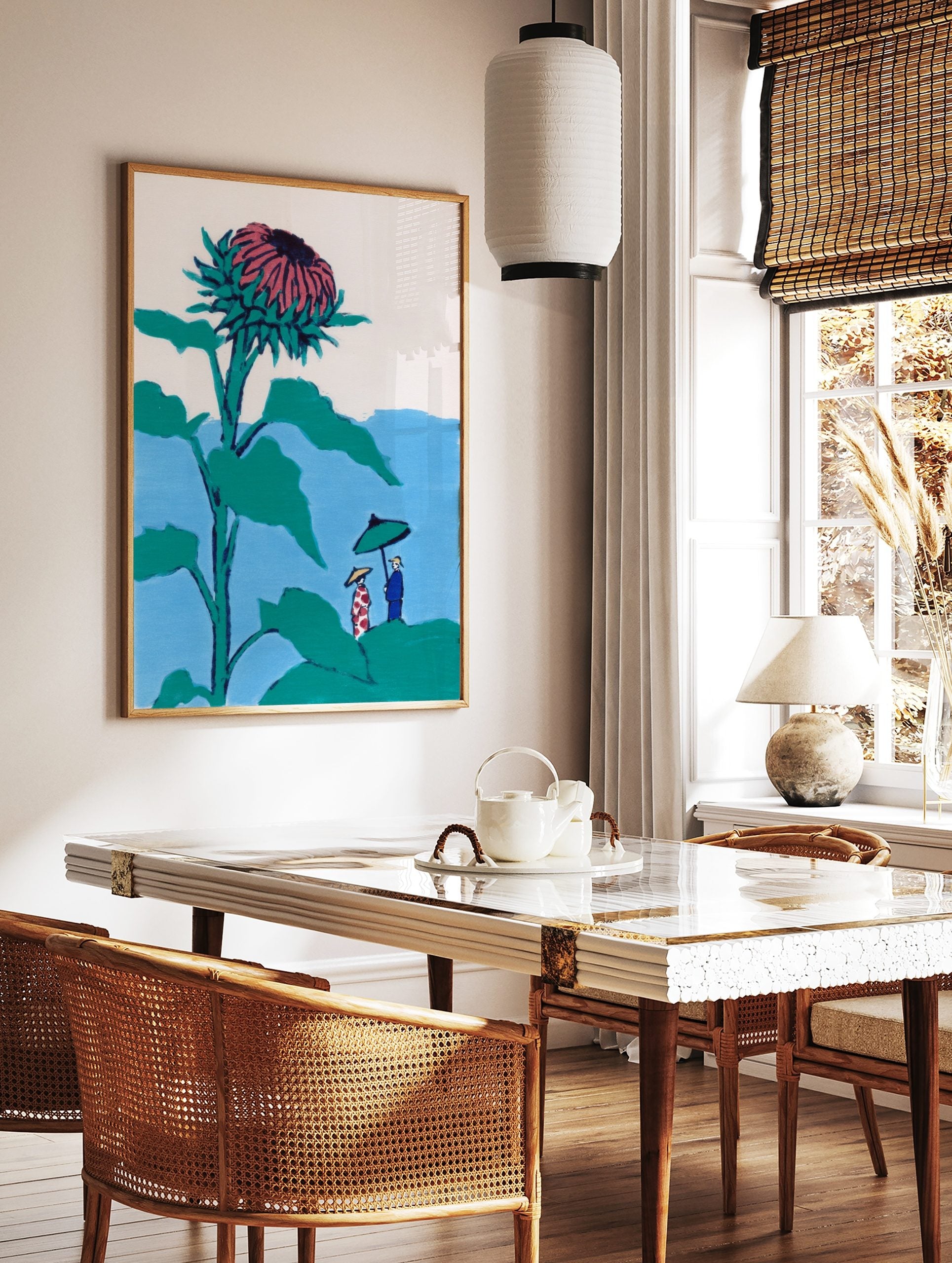 Illustrative print of a giant teal and pink thistle flower towering over two small figures with an, in a styled room mockup