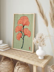 Ginkgo leaf botanical illustration with coral-red leaves and dark stem on textured teal, in an alternate framed mockup