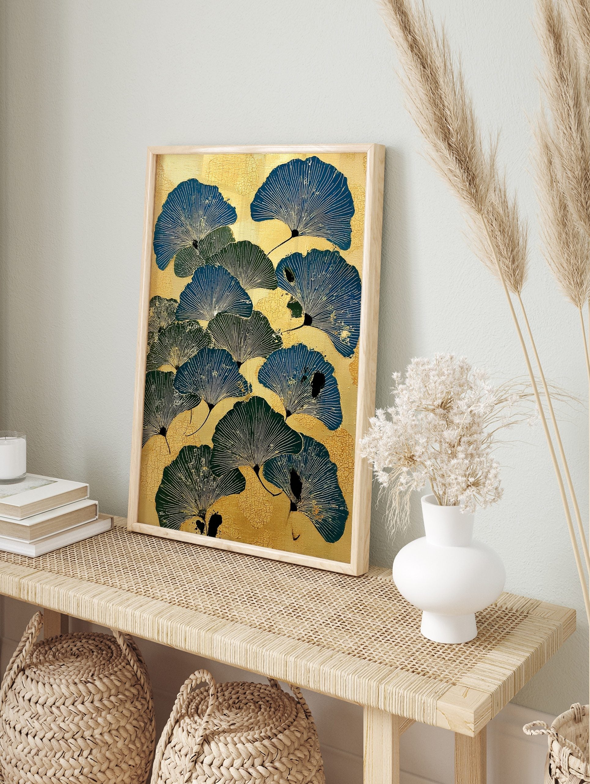 Illustrative ginkgo leaf botanical print in blue and green on a textured golden background, in an alternate framed mockup