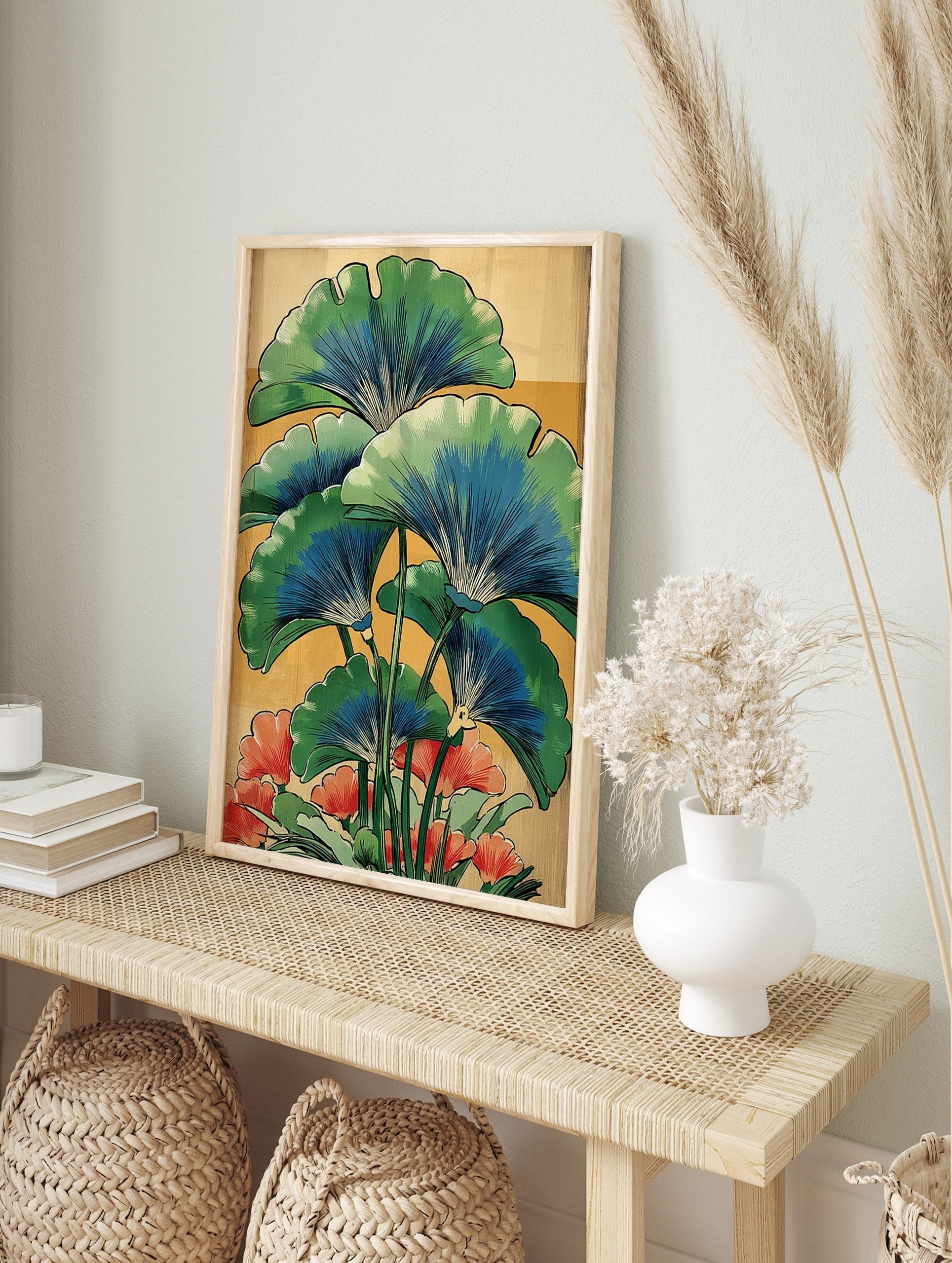 Illustrative botanical print of green and blue ginkgo leaves with red-orange flowers on a, in an alternate framed mockup