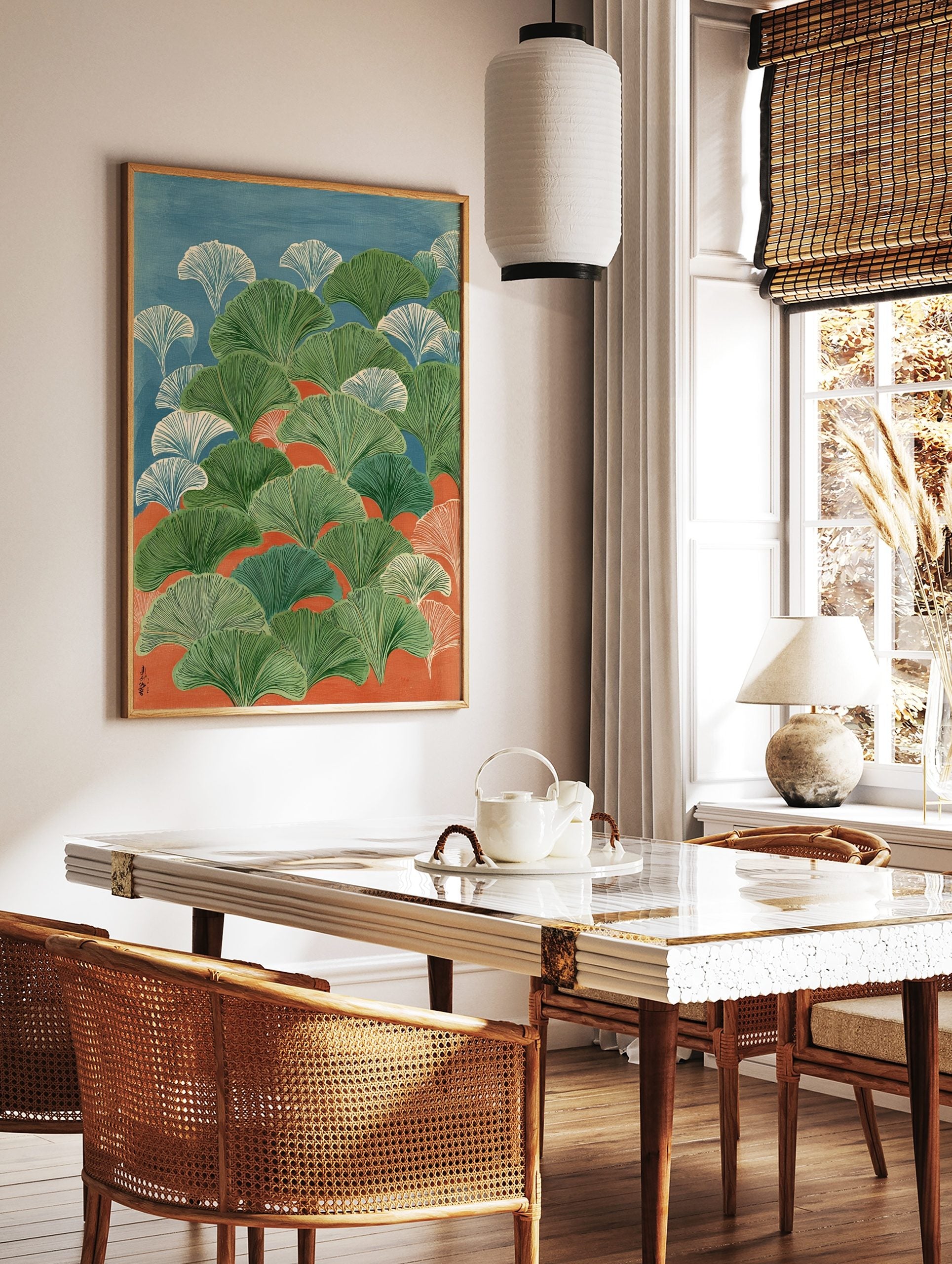 Illustrative ginkgo leaves in green and white against blue and orange background, in portrait, in a styled room mockup