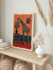 Woodcut style art print of a giraffe bending to eat leaves from a potted plant in a, in an alternate framed mockup