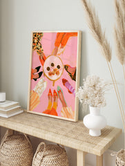 Fashion illustration of various colourful shoes in a circle around a table of treats on a, in an alternate framed mockup