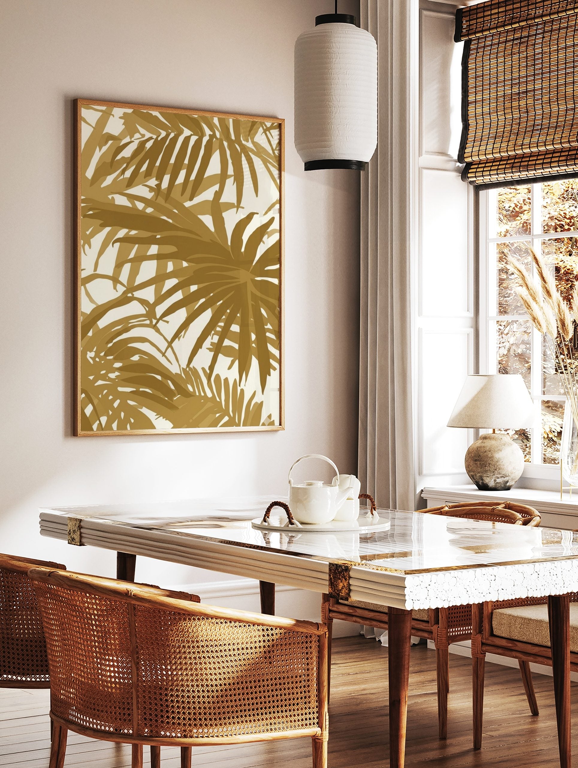 Gold palm leaf tropical botanical wall art print with overlapping foliage on a light background, displayed as the same artwork in a styled poster mockup for home decor