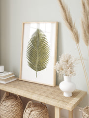 Gold palm leaf botanical illustration art print on a clean white background, tropical style, in an alternate framed mockup