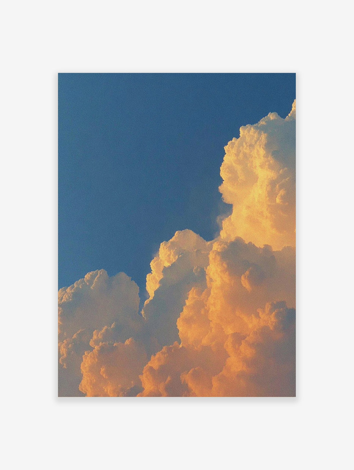 Dramatic golden cumulus clouds against a deep blue sky, capturing a vibrant sunset or sunrise