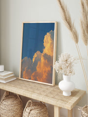 Dramatic golden cumulus clouds against a deep blue sky, capturing a vibrant sunset or sunrise, in an alternate framed mockup