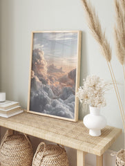 Photographic print of voluminous clouds bathed in warm golden and peach light at sunrise or, in an alternate framed mockup