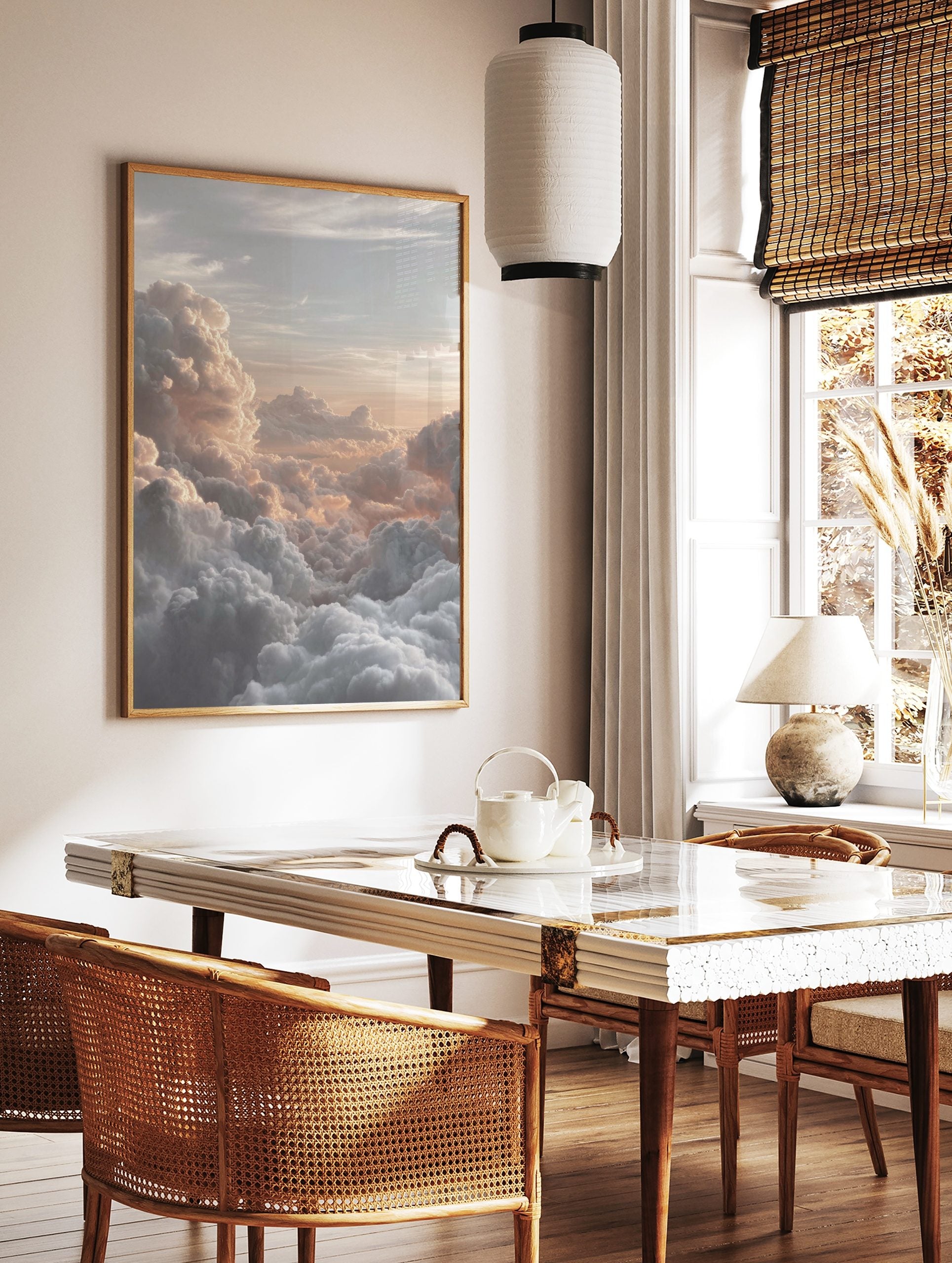 Photographic print of voluminous clouds bathed in warm golden and peach light at sunrise or sunset, in a styled room mockup