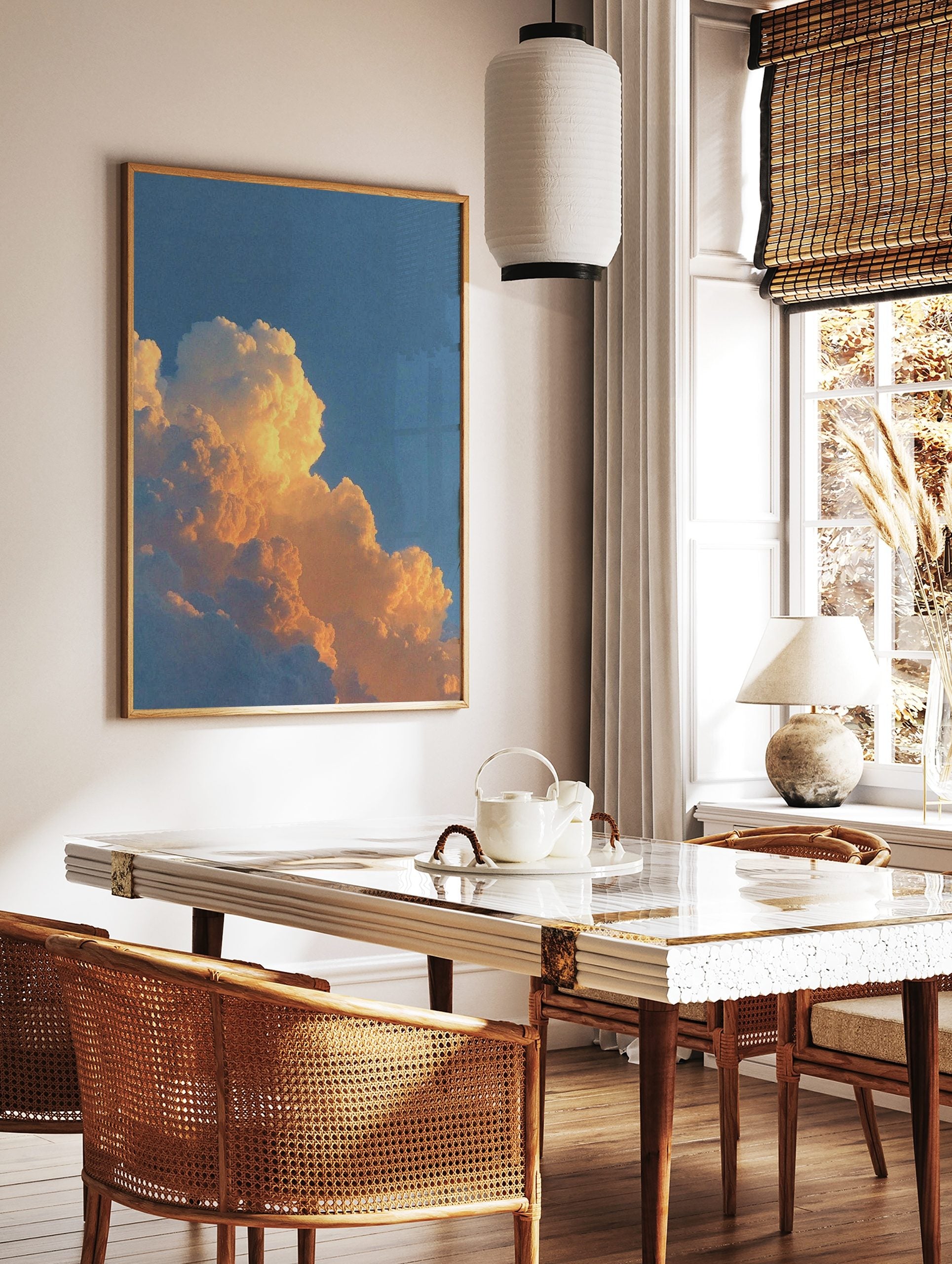Close-up of cumulus clouds bathed in warm orange and yellow light against a blue sky, in a styled room mockup