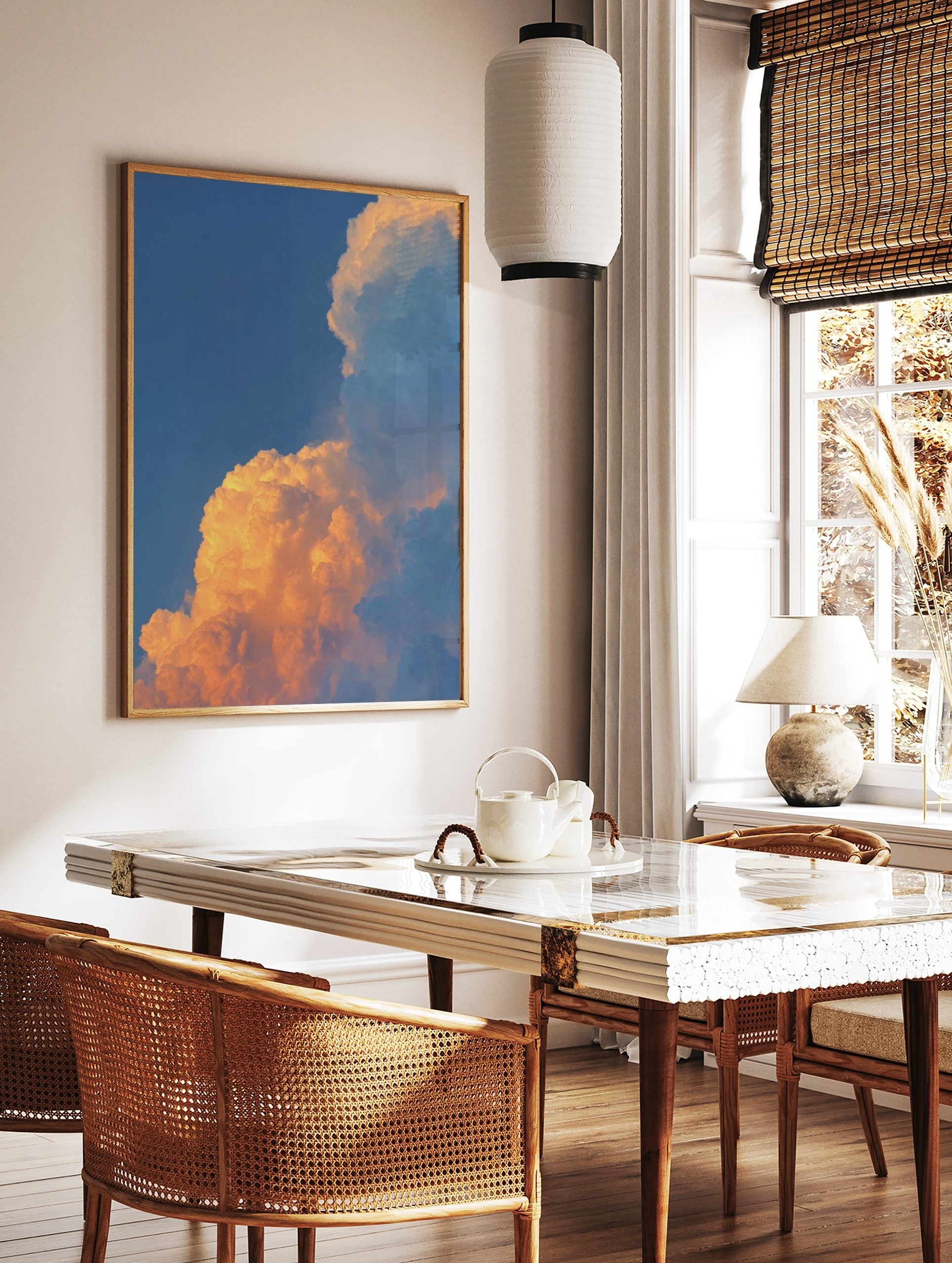 Dramatic golden orange sunset clouds against a clear blue sky, filling the frame with natural light, in a styled room mockup