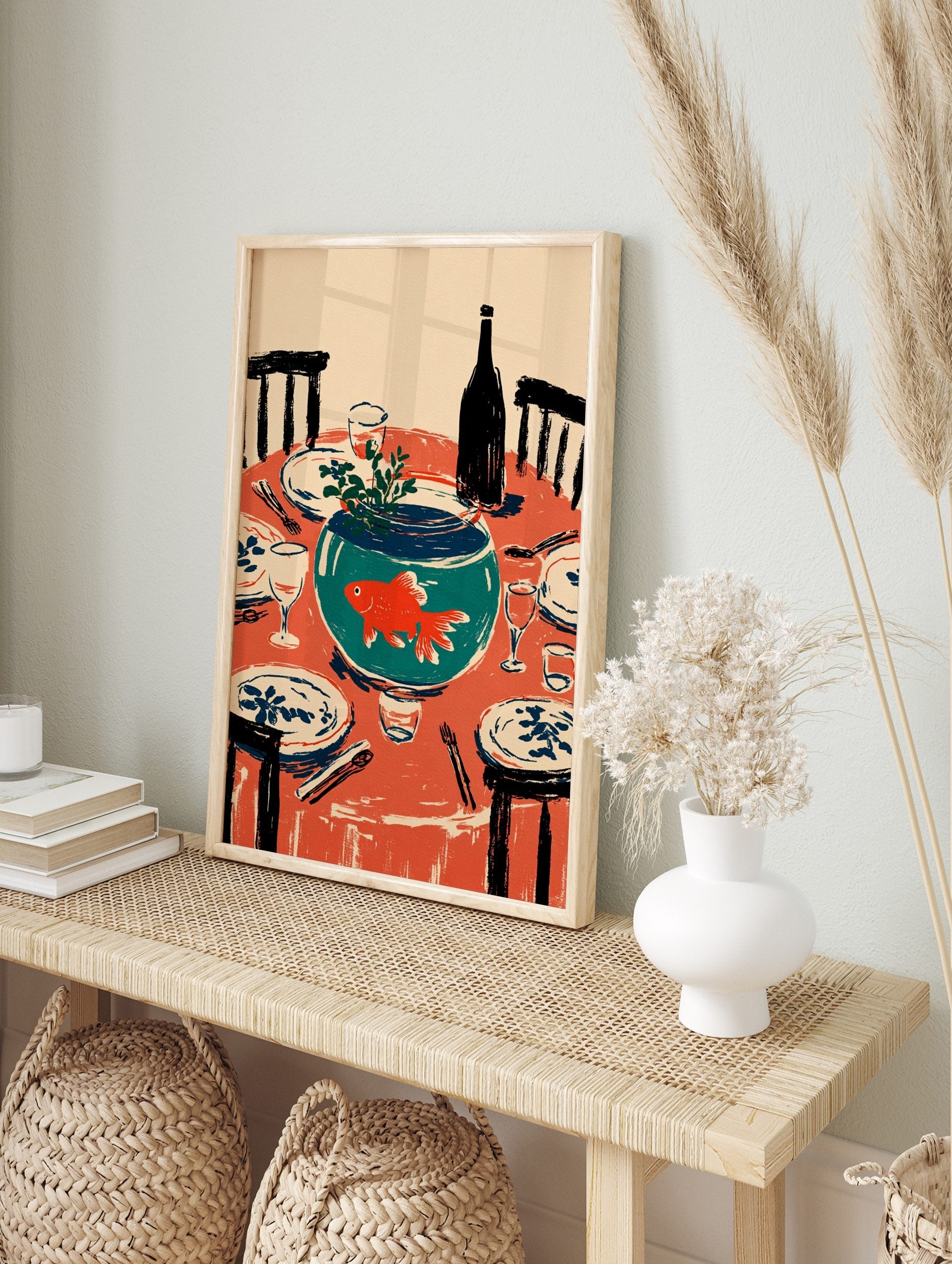 Illustrative wall art of an orange goldfish in a teal fishbowl on a red dining table set with, in an alternate framed mockup