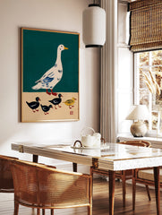 Illustrative print of a white goose with blue wings and four ducklings, three black and one yellow, in a styled room mockup