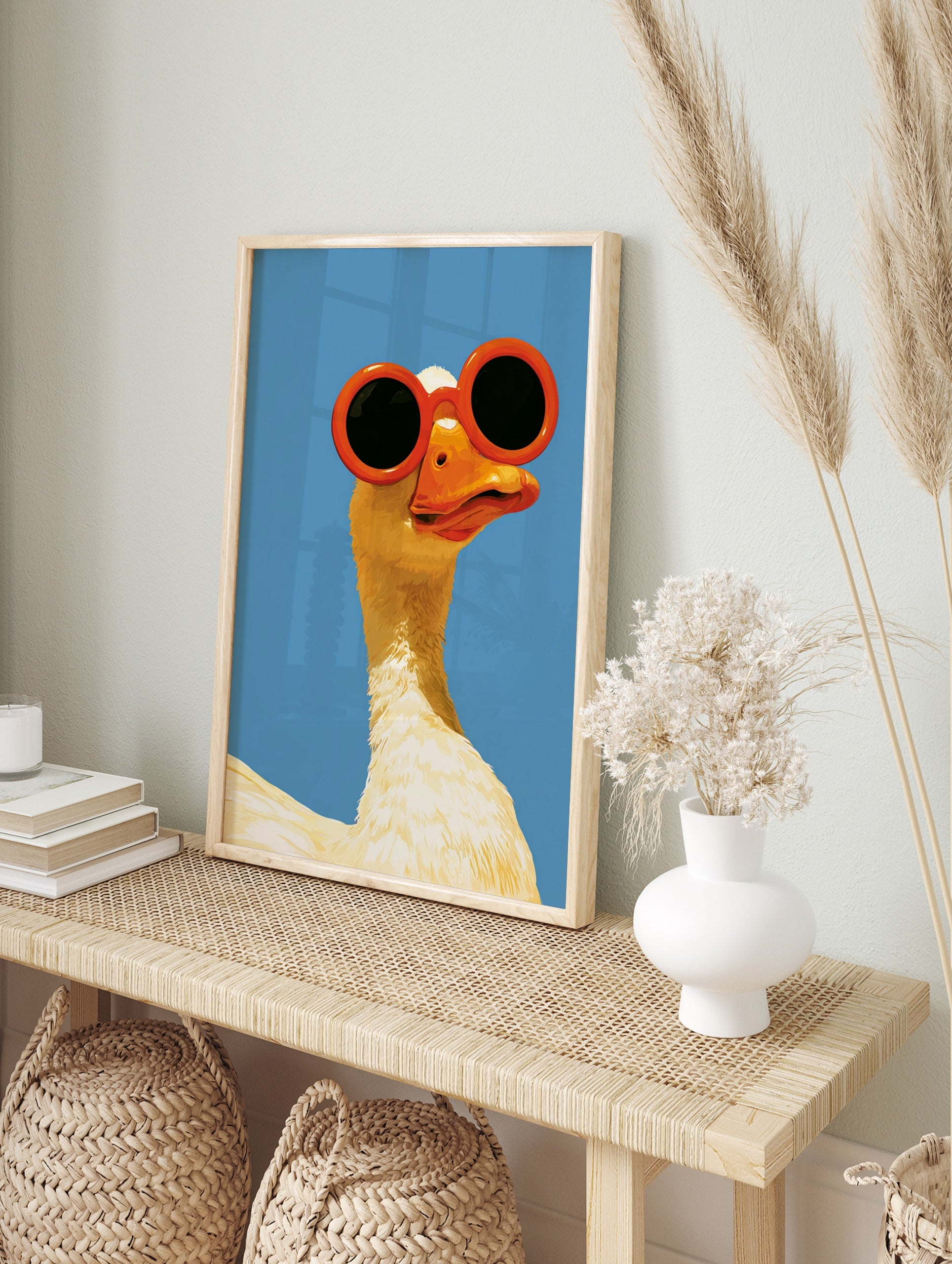 Illustration of a white goose wearing large, round orange sunglasses against a solid, bright, in an alternate framed mockup