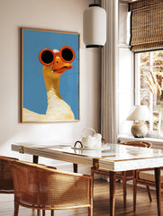 Illustration of a white goose wearing large, round orange sunglasses against a solid, bright blue, in a styled room mockup
