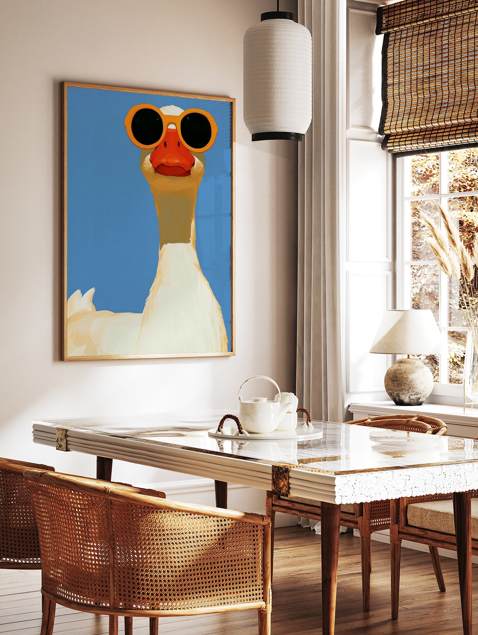 A white goose wearing large orange sunglasses against a solid blue background, illustrative animal, in a styled room mockup