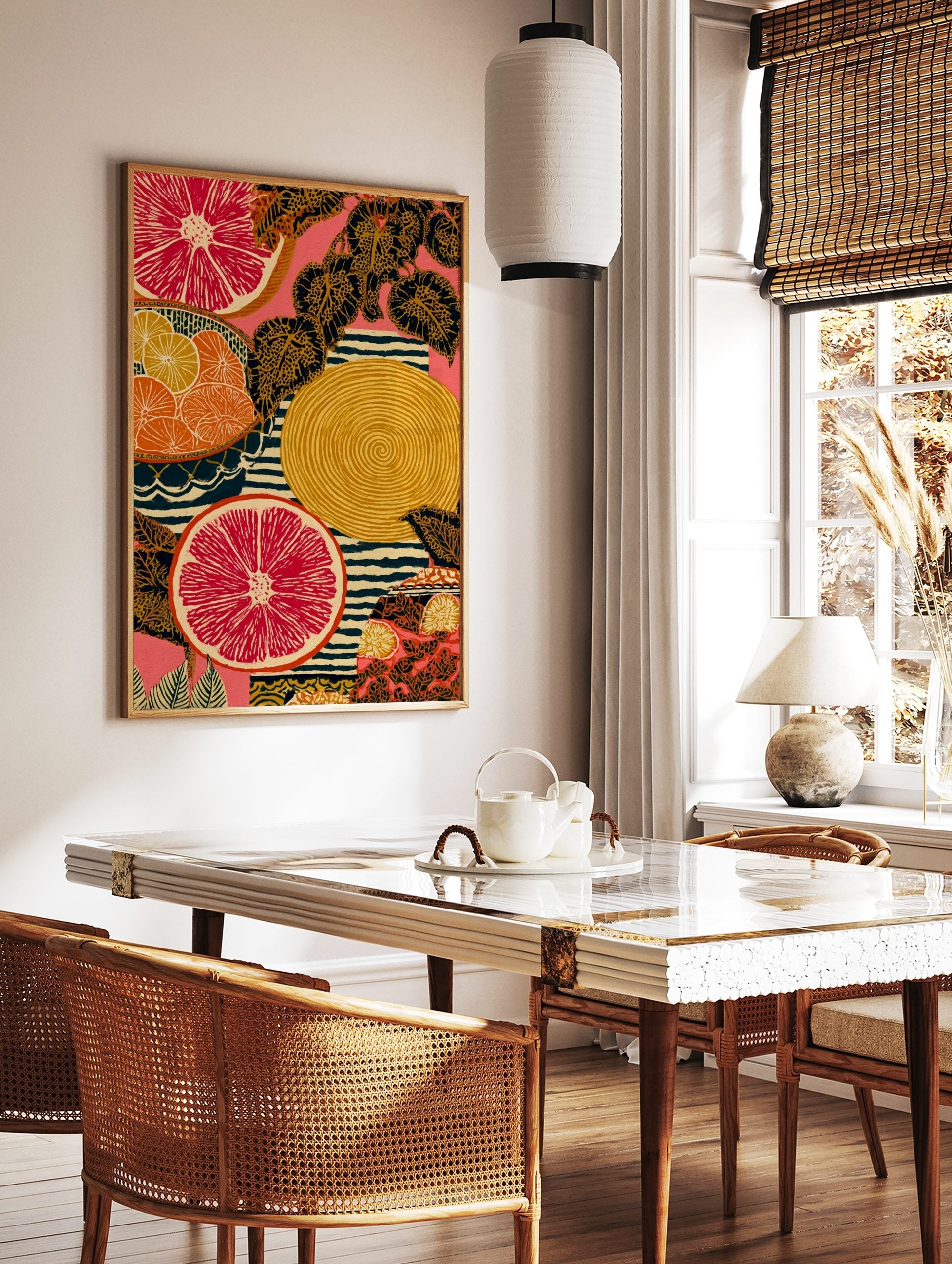 Illustrative art print of sliced red grapefruit, orange citrus, patterned leaves, and stripes on a, in a styled room mockup
