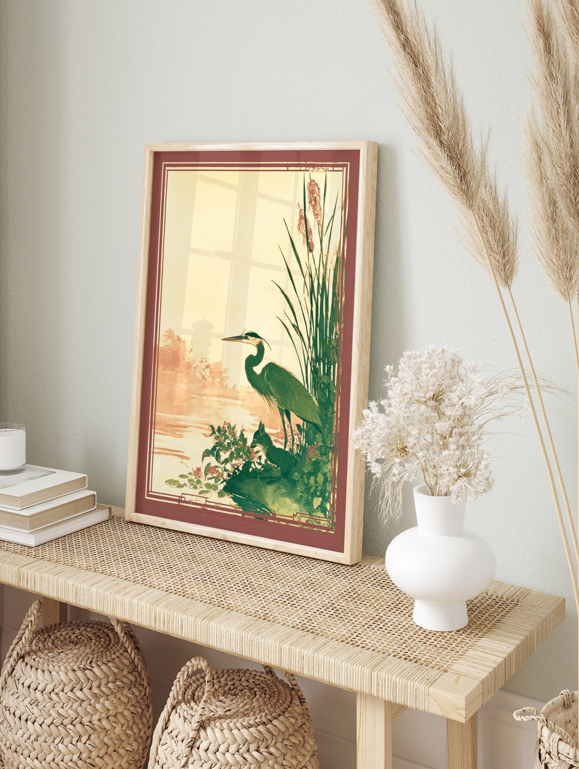 Illustrative great blue heron and fox by a pond with reeds, in green, brown, and beige tones, in an alternate framed mockup