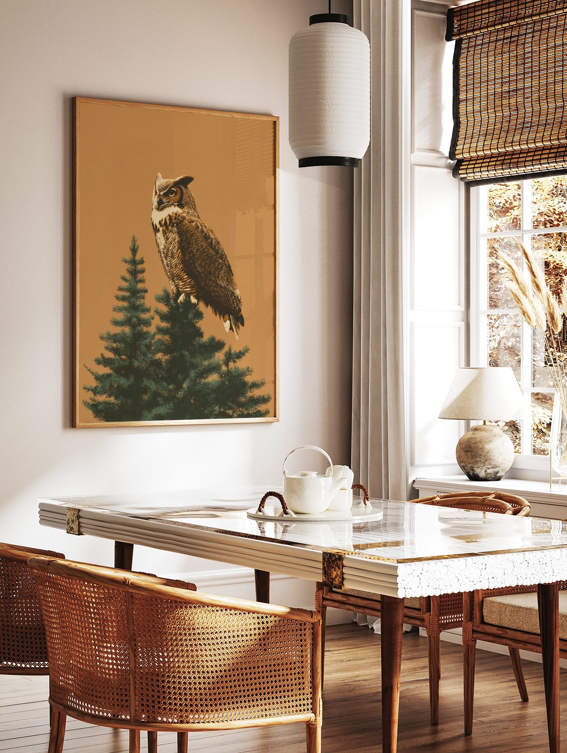 Illustrative great horned owl perched on a green evergreen tree branch against a warm tan background, in a styled room mockup
