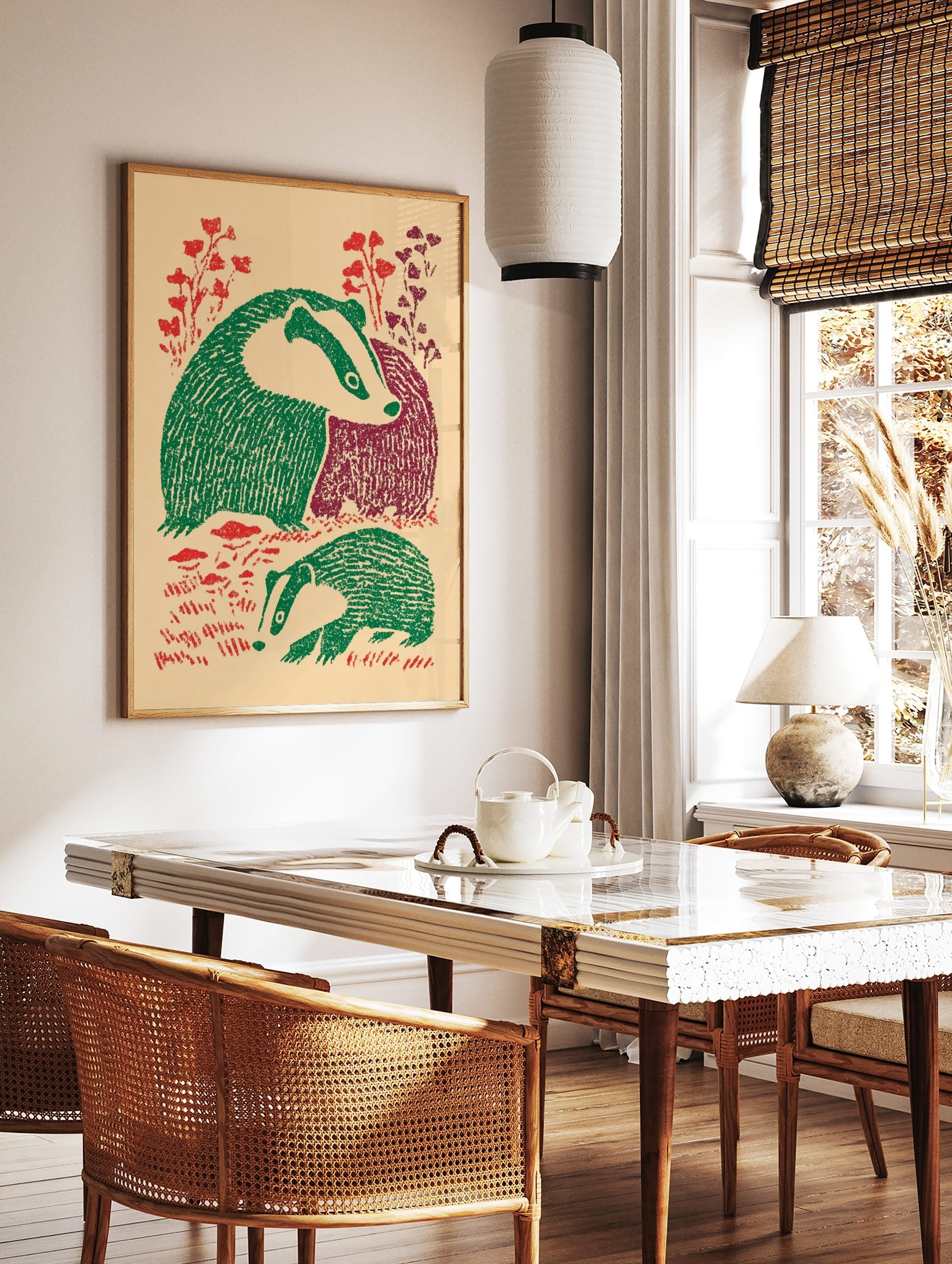 Illustrative print of two badgers with green and maroon bodies, red foliage, on a beige background, in a styled room mockup
