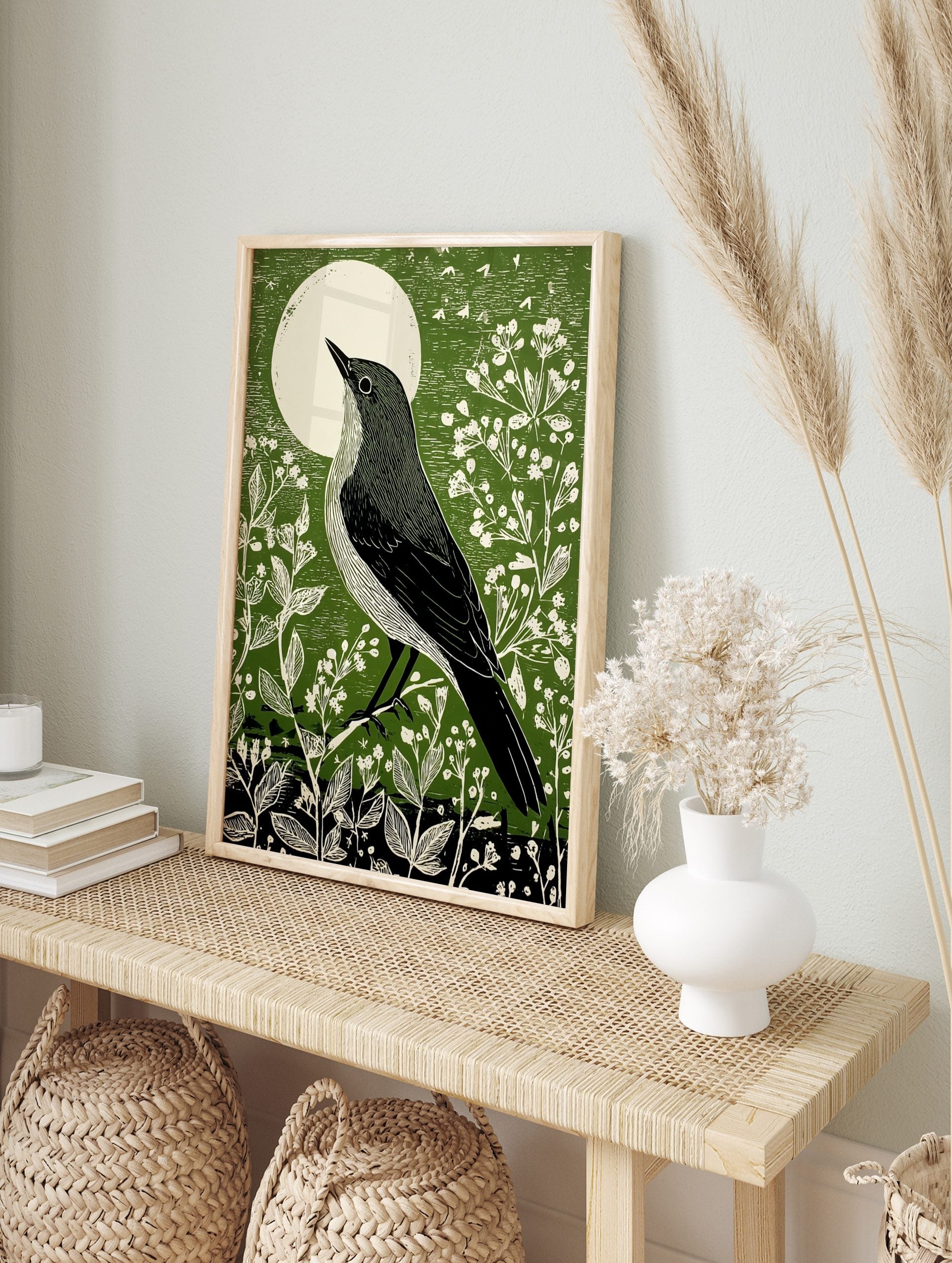 Illustrative green bird art print looking at a white moon, surrounded by white botanical, in an alternate framed mockup