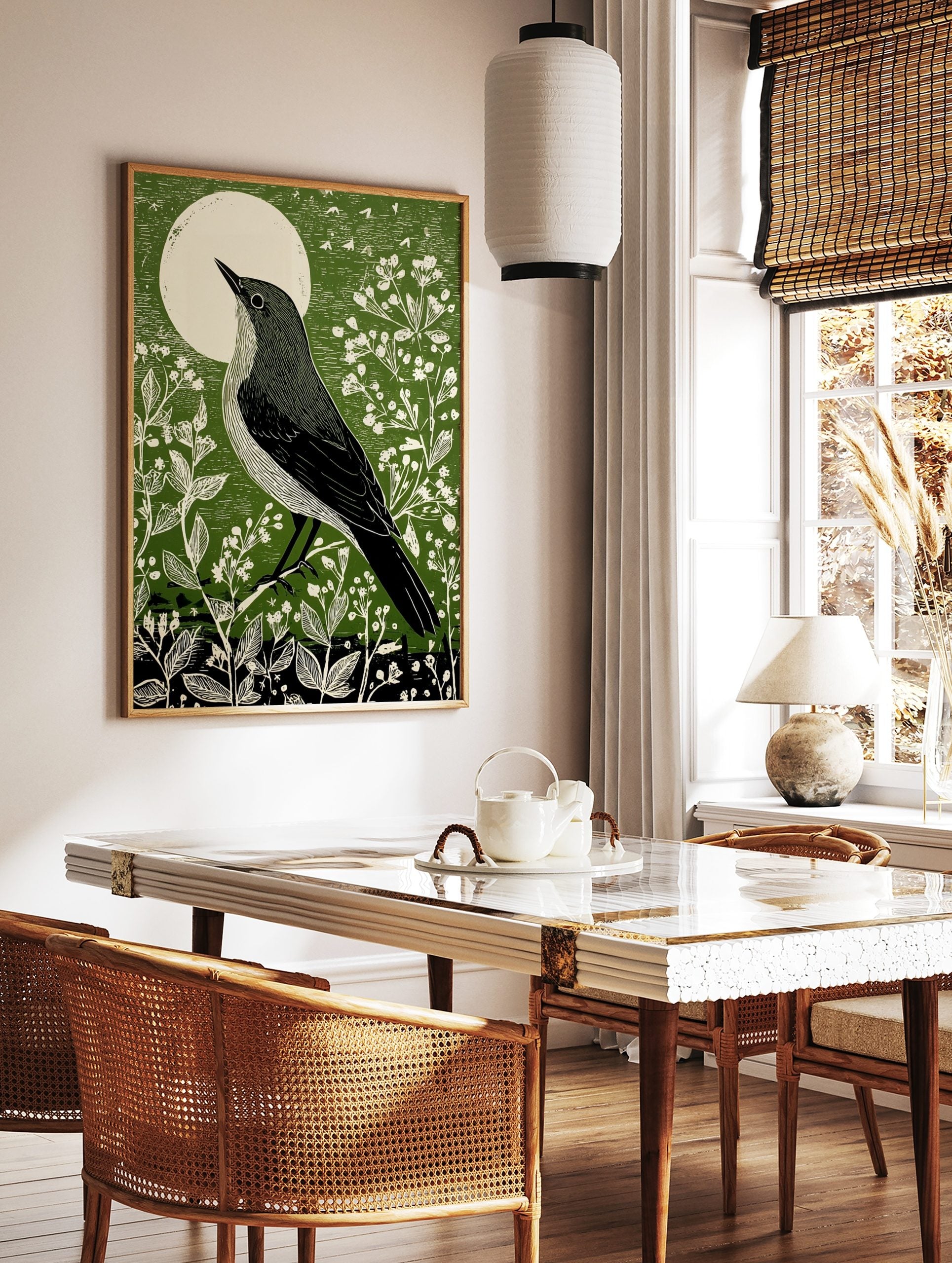 Illustrative green bird art print looking at a white moon, surrounded by white botanical plants, in a styled room mockup