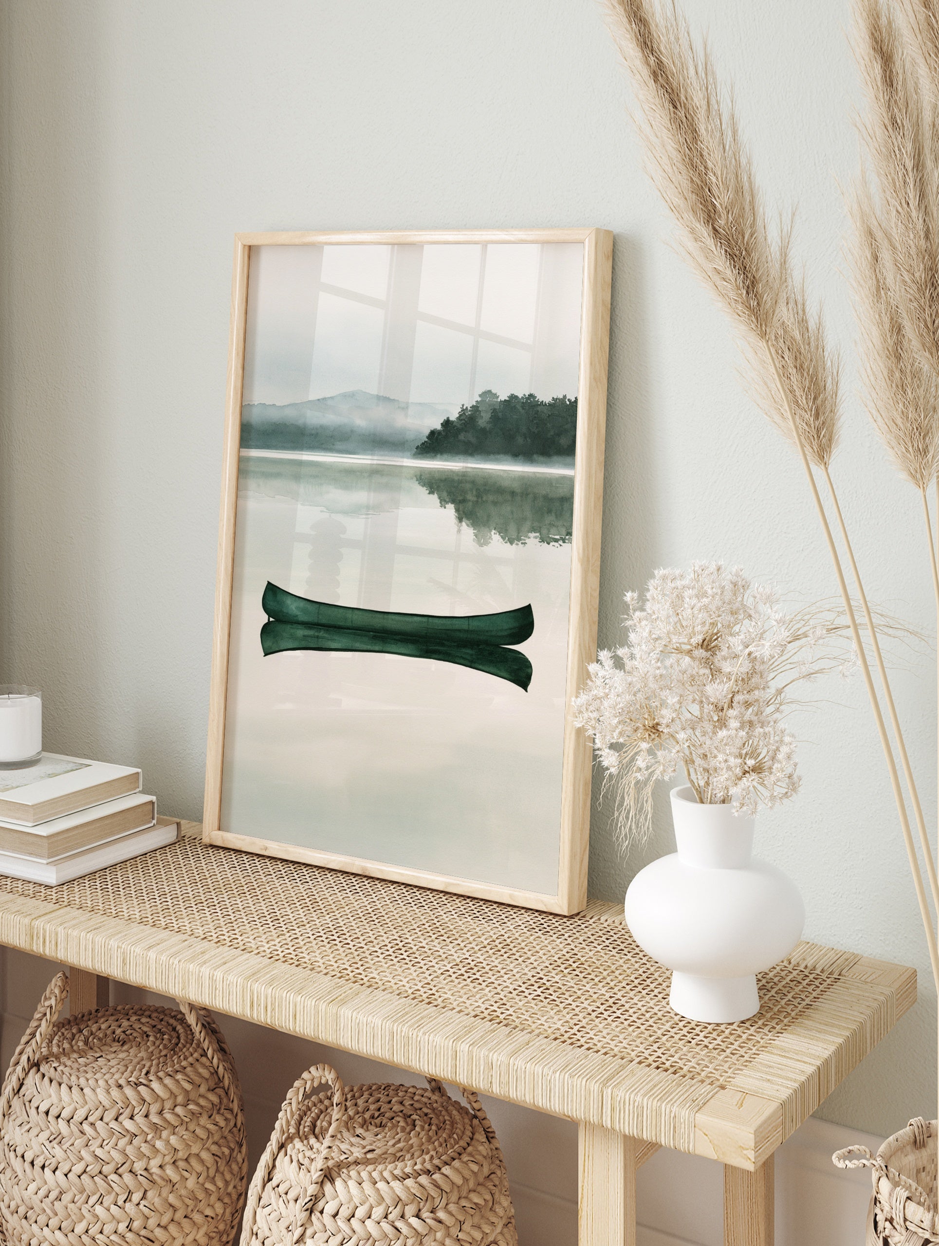 Green canoe floating on a calm, misty lake with a mountain and forest background in a, in an alternate framed mockup